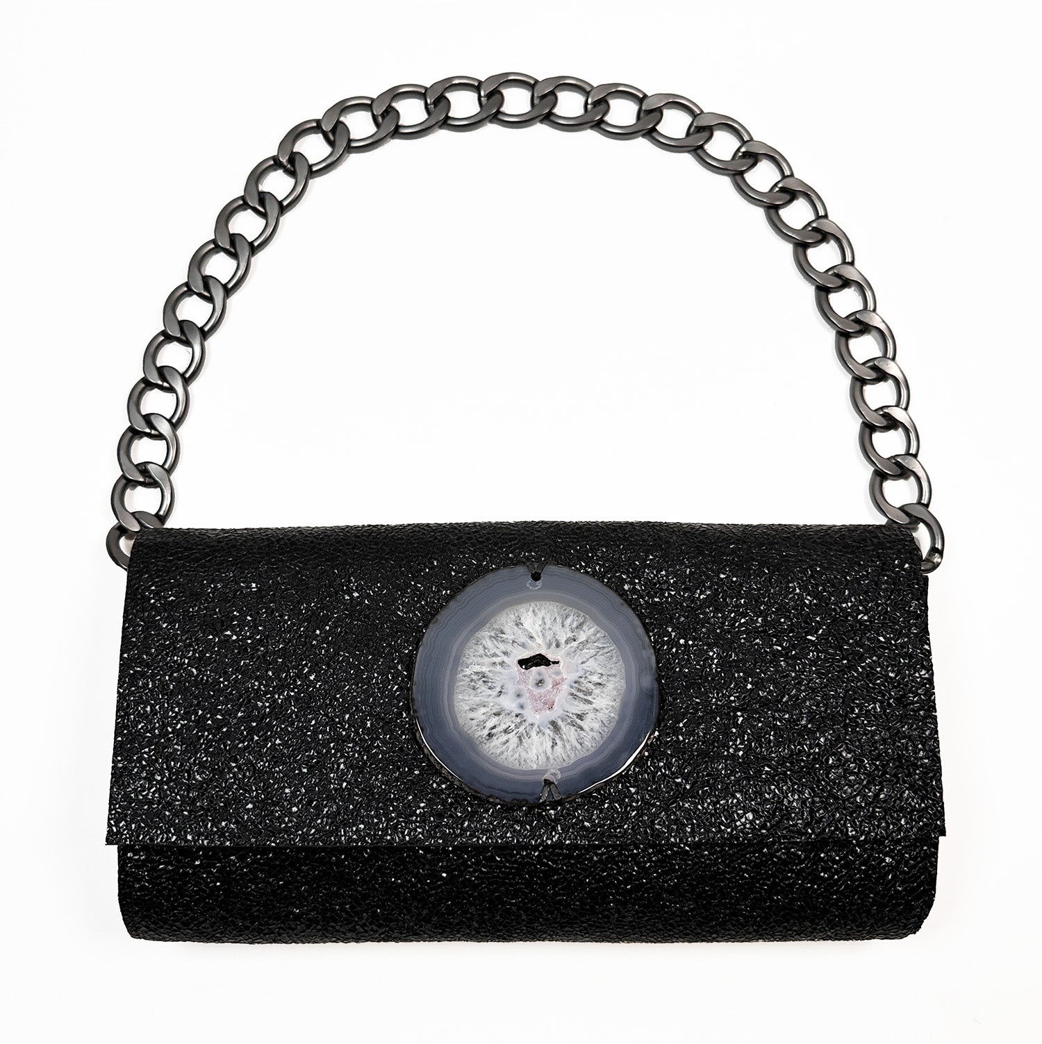 The BAGUETTE by Evoke Women – a sleek handbag crafted from textured black Italian leather, featuring a bold gunmetal chain strap and a round agate centerpiece, elegantly displayed on a white background.