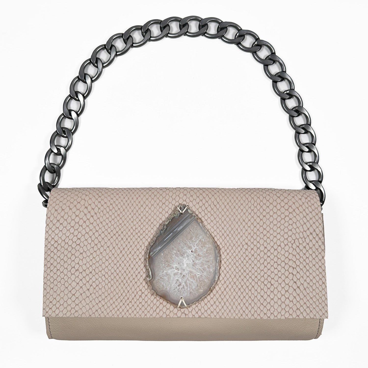 Powder hued snake embossed leather baguette clutch with crystal white and grey teardrop-shaped agate and gunmetal colored large link shoulder chain on white background.
