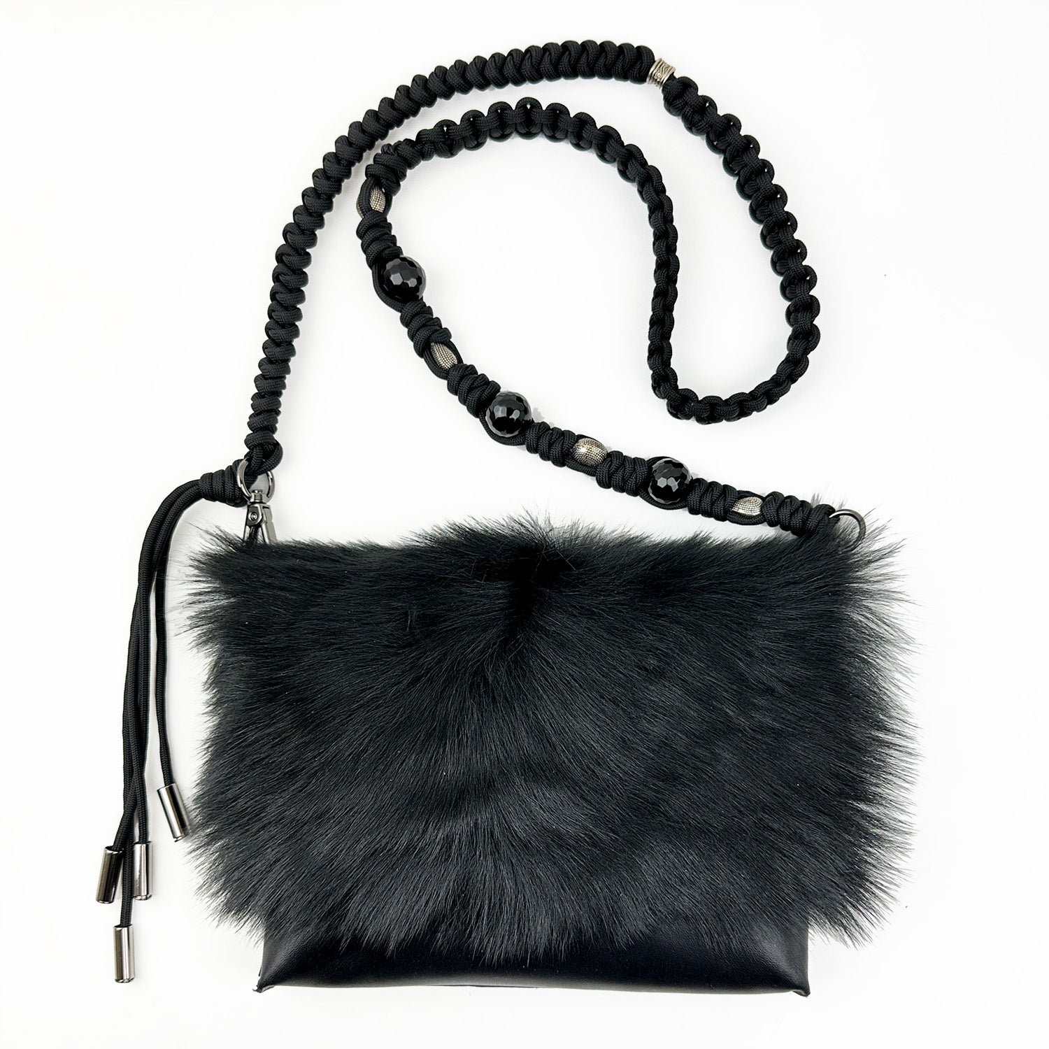 The BAHAMA FUR - BLACK - KNOTTED STRAP by evokewomen, featuring a faux fur design with a knotted shoulder strap and metal accents, is displayed on a white background.