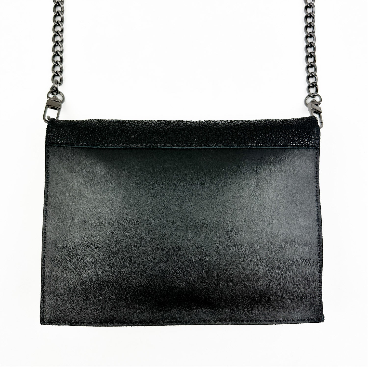 The BAHAMA - BLACK STINGRAY shoulder bag by evokewomen, featuring black Italian leather and a chain strap, exudes exotic allure against a white background.