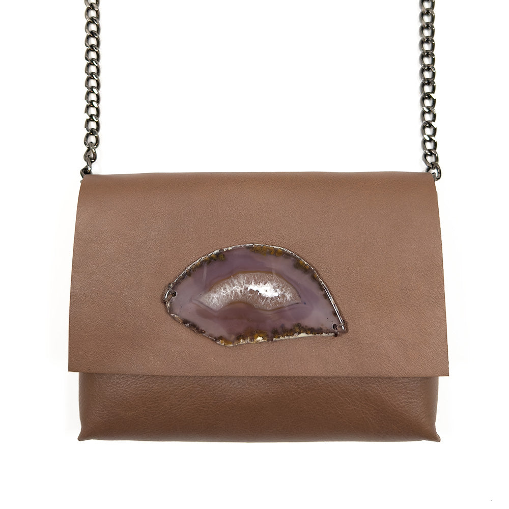 Introducing the BAHAMA - nutshell by evokewomen: a versatile Italian leather purse in brown, featuring a flap closure and adorned with a polished agate stone on the front. It comes with a sleek black chain shoulder strap, making it perfect for use as a crossbody bag.