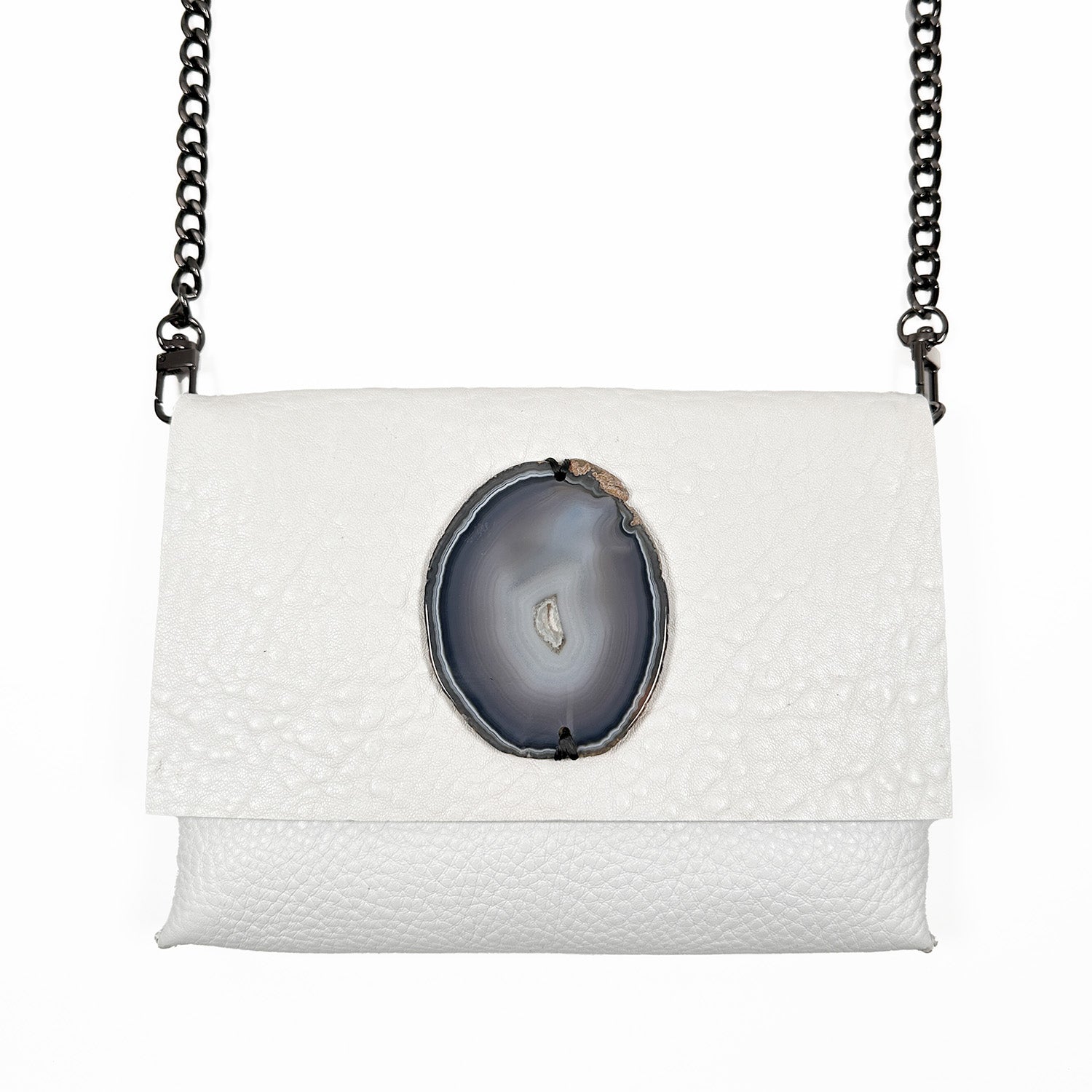 The BAHAMA - white by evokewomen is an Italian leather cross body bag with a central geode detail and a black metal chain strap, offering a versatile design ideal for any occasion.