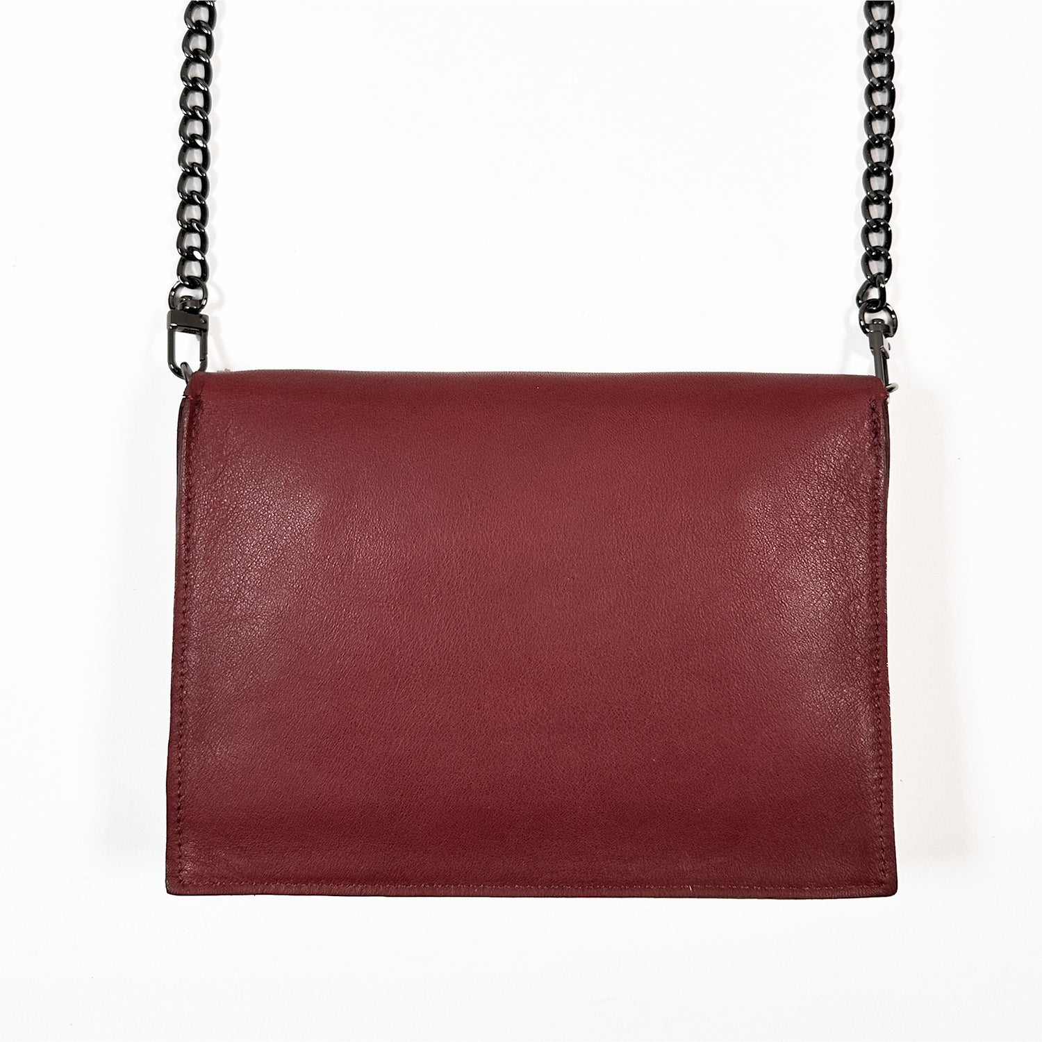 The BAHAMA - wine by evokewomen, crafted from luxurious Italian leather, showcases a red design with a sleek black crossbody chain set against a pristine white background.