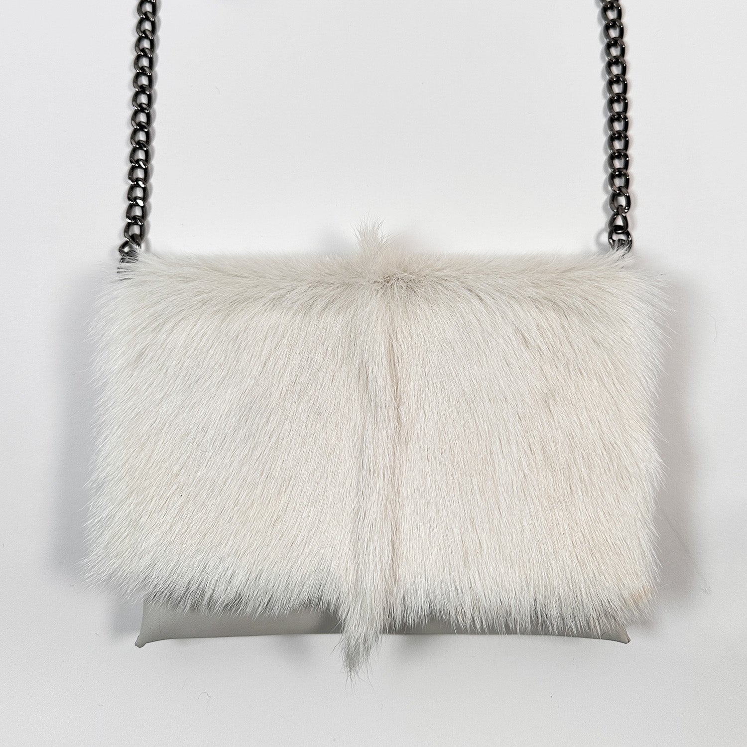 The BAHAMA FUR - WINTER WHITE by evokewomen is a luxury bag highlighted by its white fur exterior and stylish metal chain strap, elegantly displayed against a plain white background.