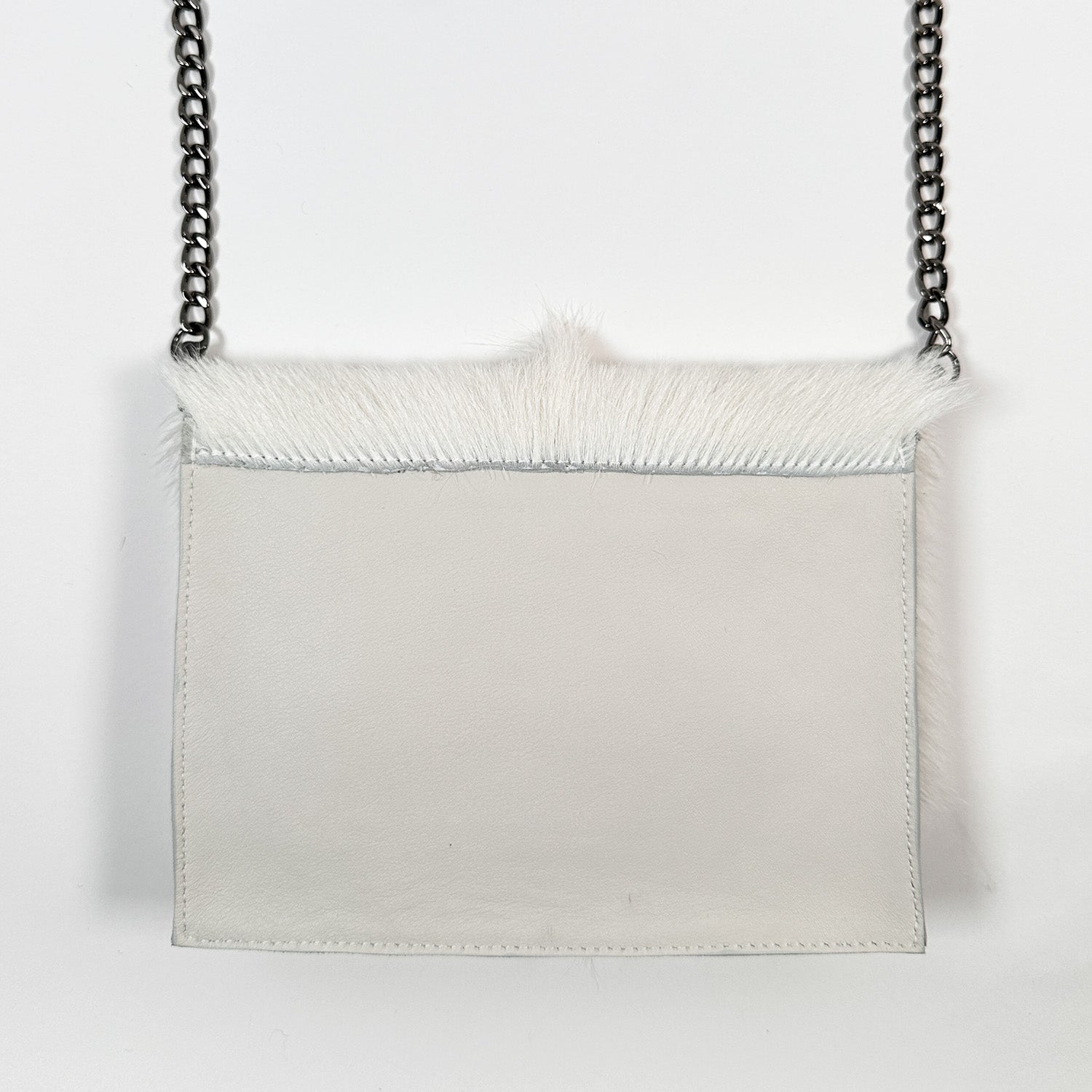 The BAHAMA FUR - WINTER WHITE by evokewomen, a luxurious white leather purse featuring a furry trim and chain strap, hangs elegantly against a plain background. This versatile bag effortlessly combines style and sophistication for any occasion.