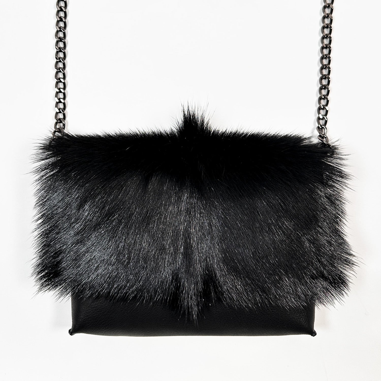 The BAHAMA FUR - BLACK by evokewomen, a luxurious fur handbag with a chain strap, stands elegantly against a white background.