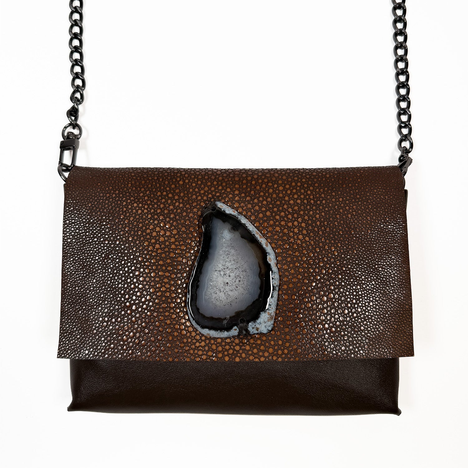 Alt description:
A chocolate-brown leather shoulder bag with a textured faux stingray flap. Centered on the flap is a large, polished black agate slice with natural stone striations. The bag features a dark gunmetal chain strap.