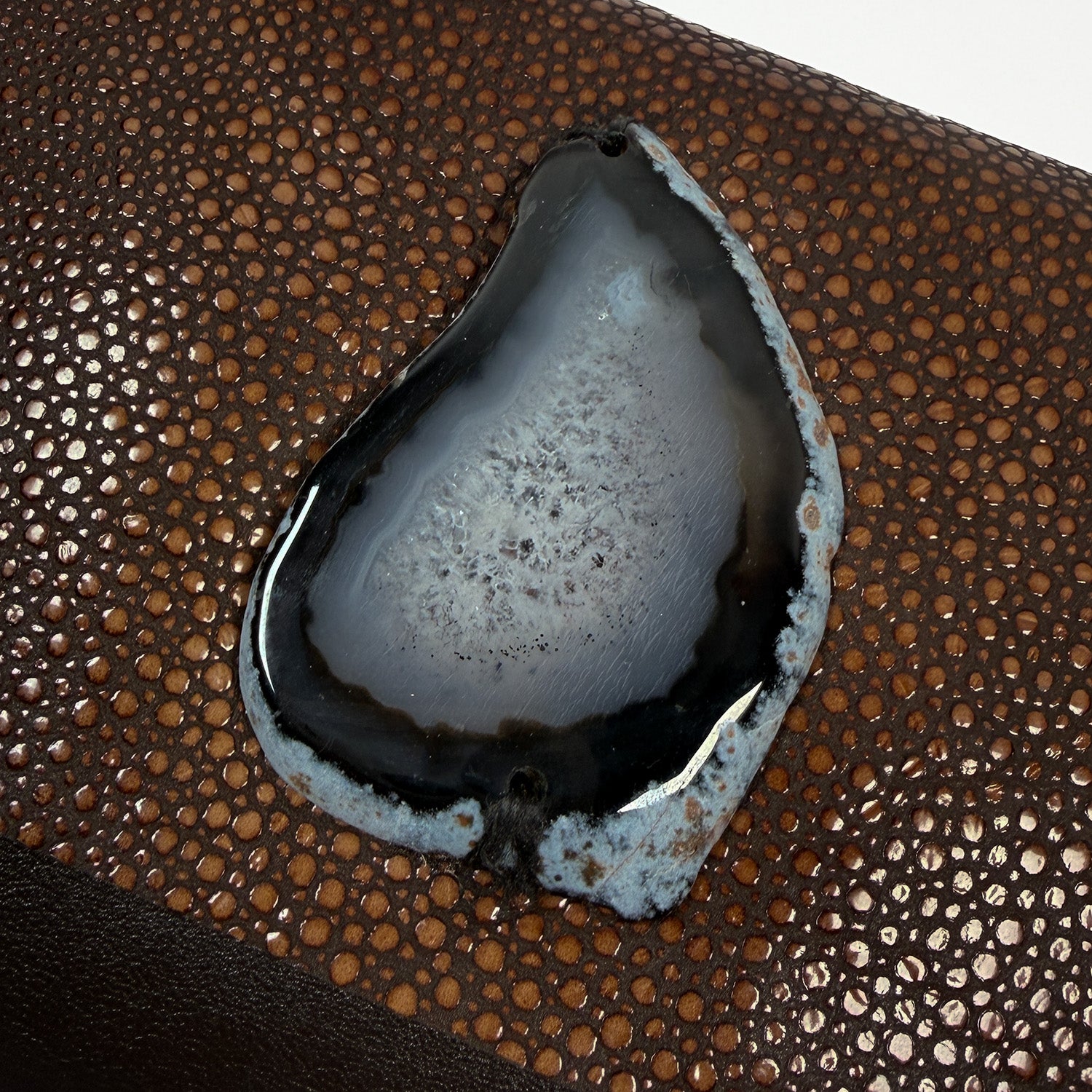 Close-up of a Stingray textured brown leather with a central black and black and white druzy Agate.