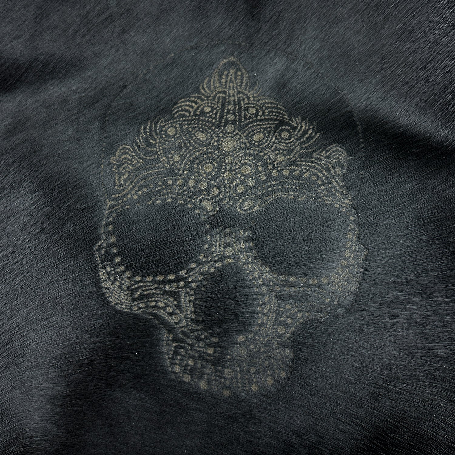 The ENYA - BLACK LASER SKULL crossbody bag by evokewomen features an ornate skull design etched into its dark surface, crafted from exquisite Italian leather with intricate patterns.