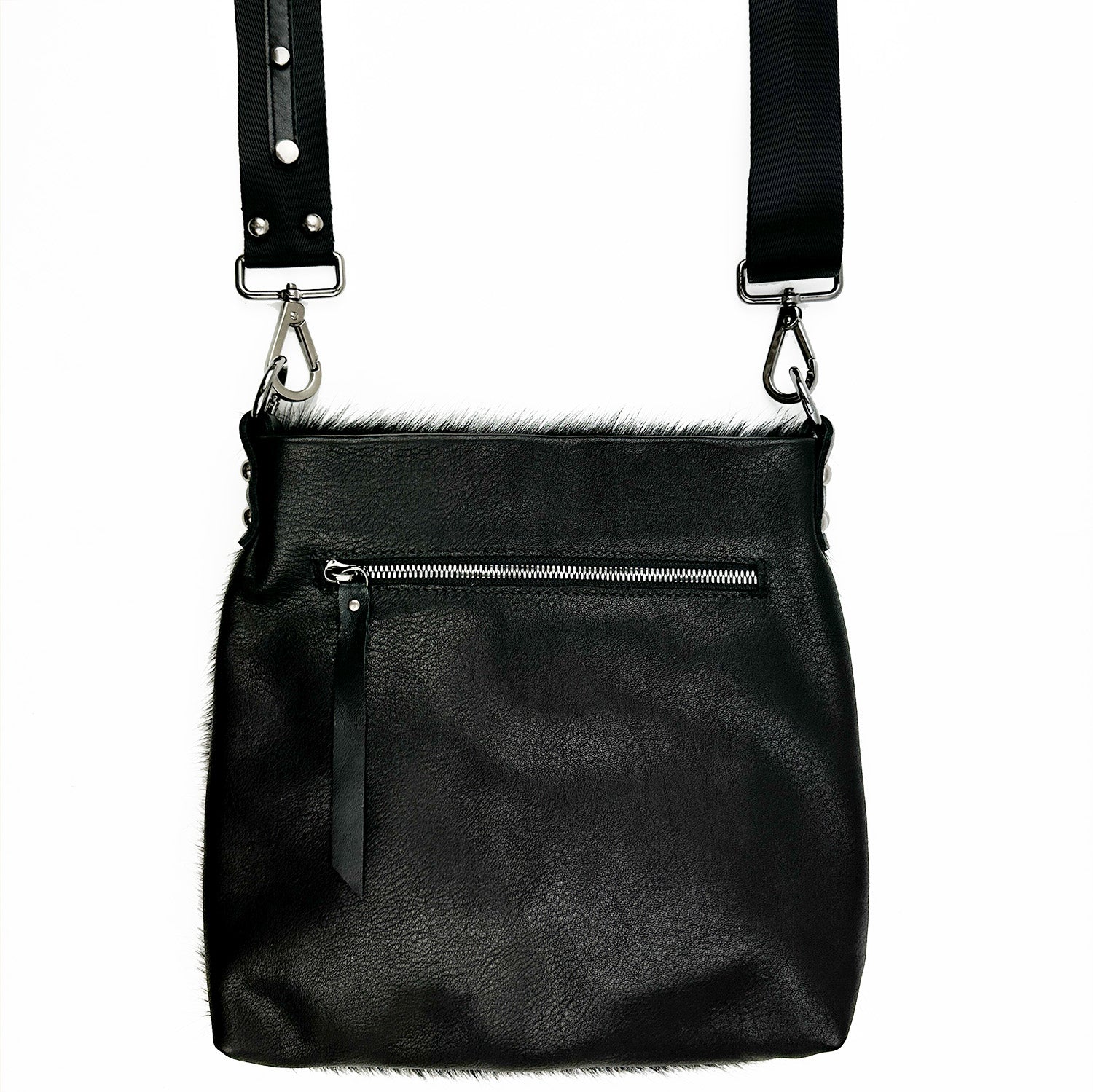 The ENYA - BLACK LASER SKULL by evokewomen is a black Italian leather crossbody bag with a skull design, featuring an adjustable strap, silver hardware, and a front zipper pocket.