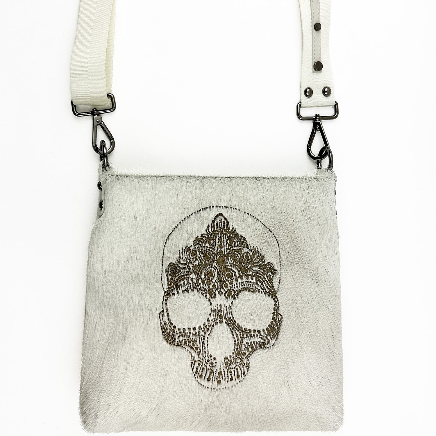 The ENYA - OFF-WHITE LASER SKULL by evokewomen is made from Italian leather and features a textured surface adorned with an intricate skull laser design at the center. It comes with a detachable shoulder strap that is elegantly secured by metal clasps.