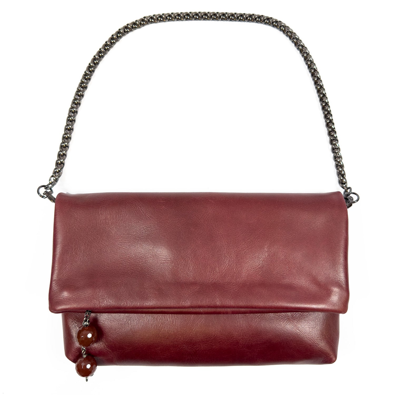 Farah - wine by evokewomen is a maroon leather cross-body bag featuring a fold-over flap with a chain strap. It is adorned with two decorative beads and a stone charm on one side.