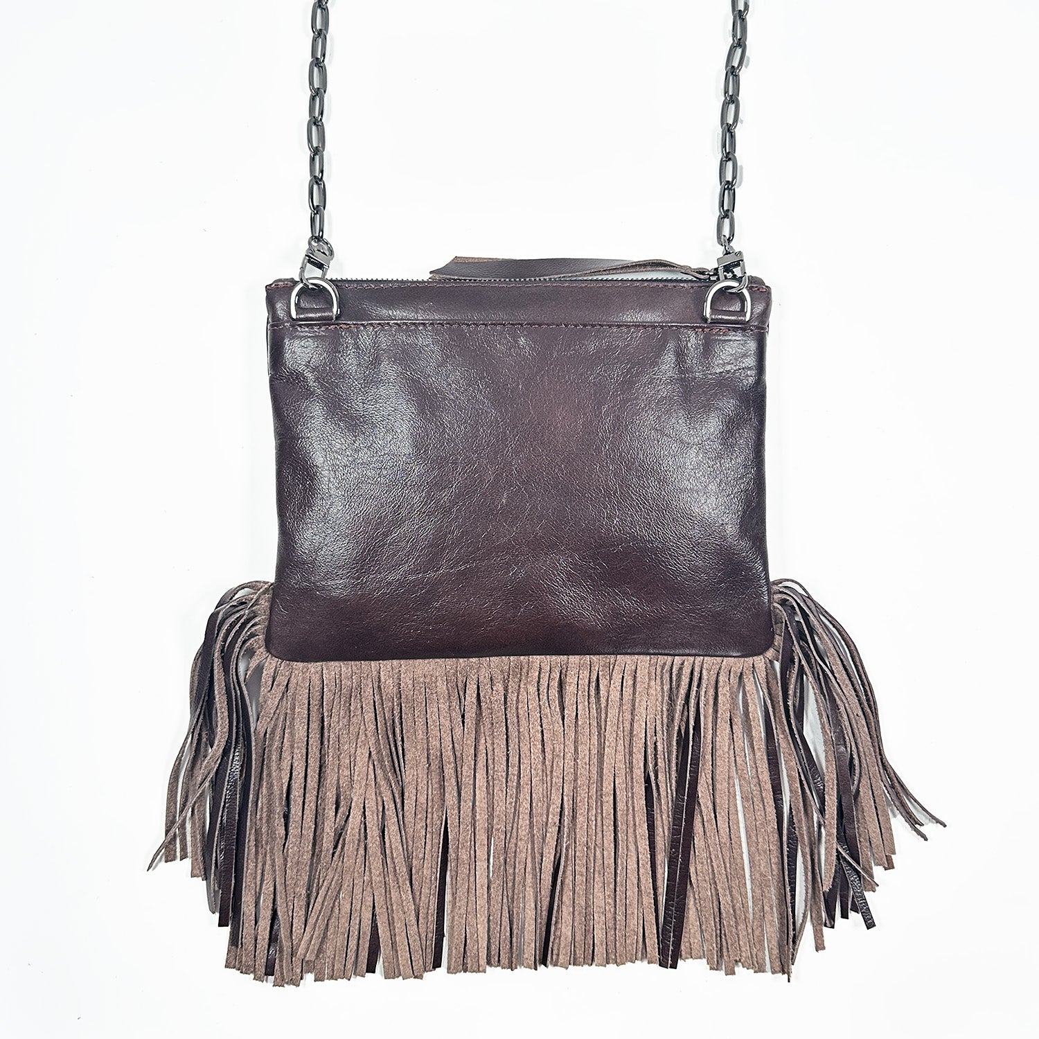 Backside of reddish brown fringe bag with zipper closure on white background. Gunmetal cross-body chain.