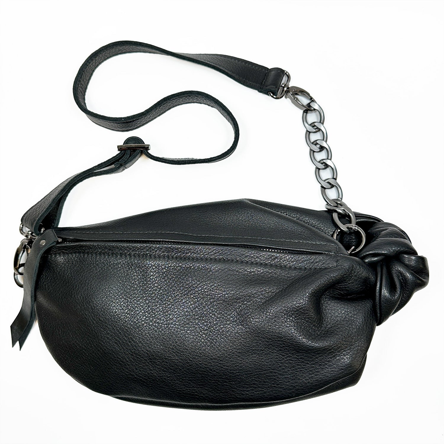 This sophisticated LONDON - BLACK crossbody bag from evokewomen, crafted with luxurious black leather and featuring a chain strap and zipper closure, elegantly stands out against a white background.