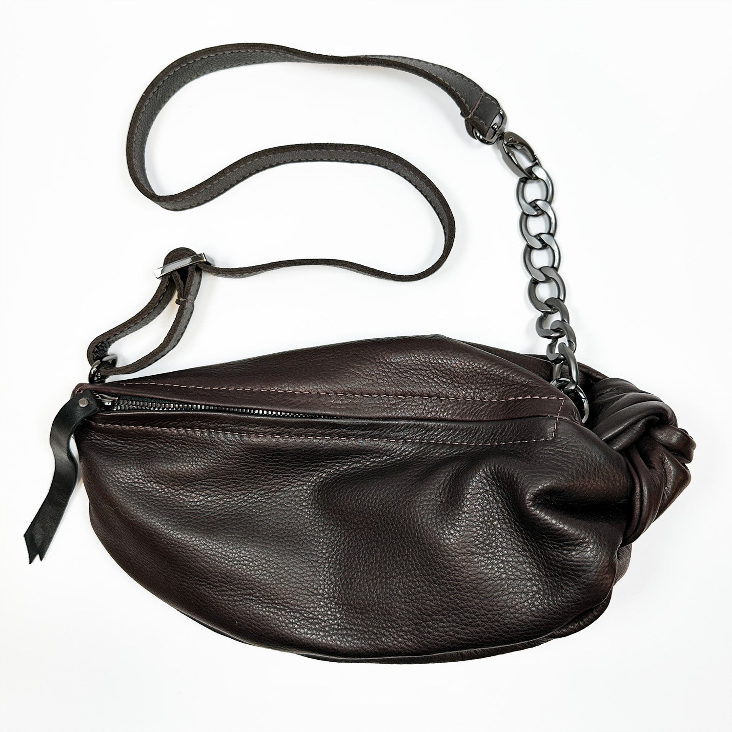 Product Description: The LONDON - BROWN by evokewomen is a dark brown leather cross body bag featuring a chain-link strap and zipper closure, showcased on a white background.