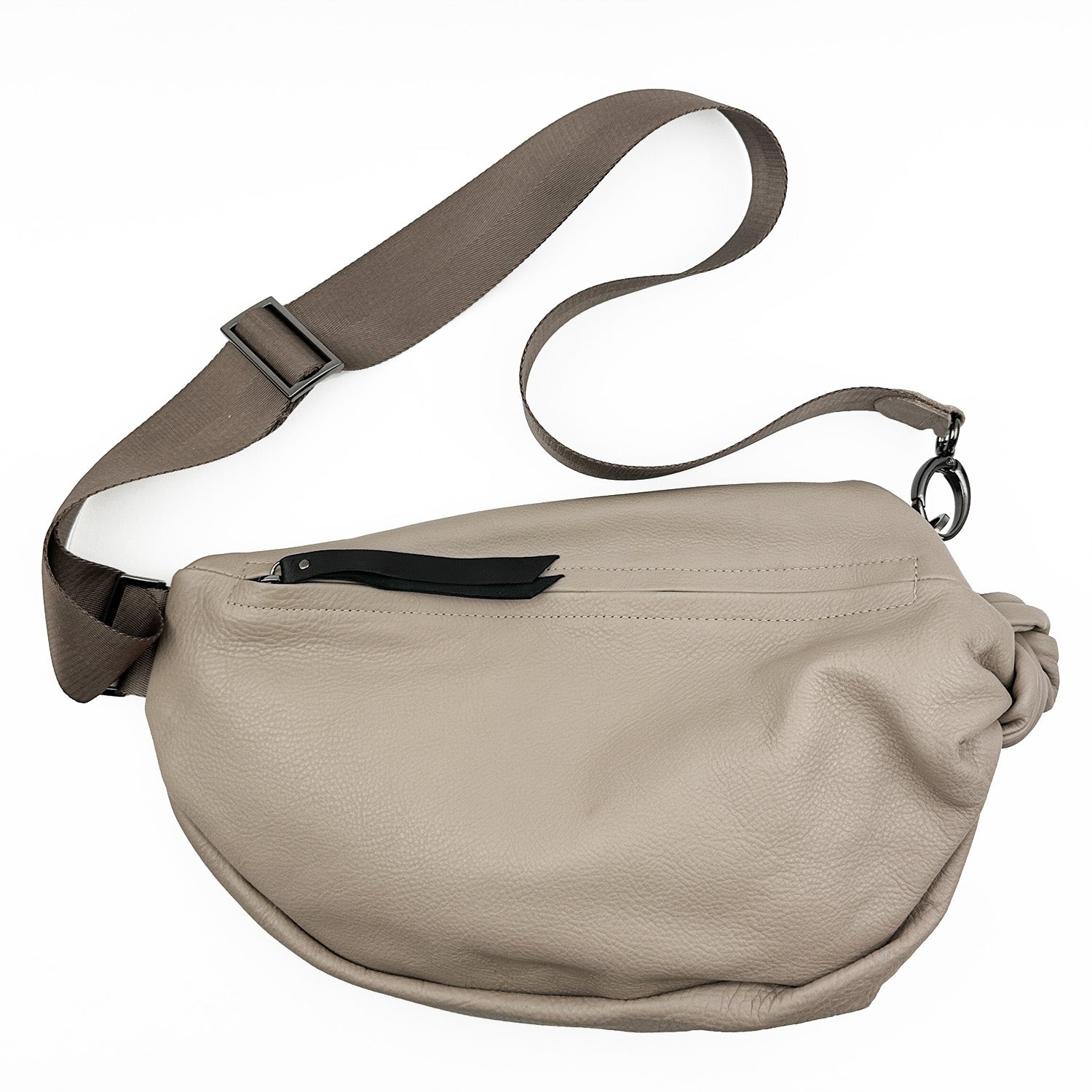 Introducing the LULA - SAND by evokewomen: a taupe leather sling bag featuring a black adjustable strap and secure zipper closure.