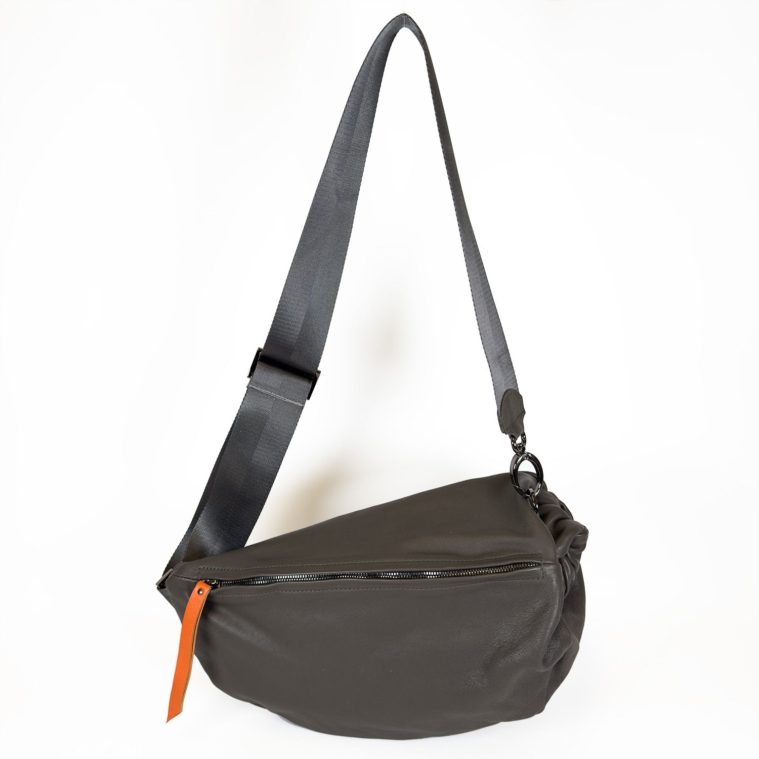 Introducing the evokewomen LULA bag in Olive-Grey, crafted with leather and featuring an adjustable shoulder strap and zipper closure, highlighted by a small orange leather puller.