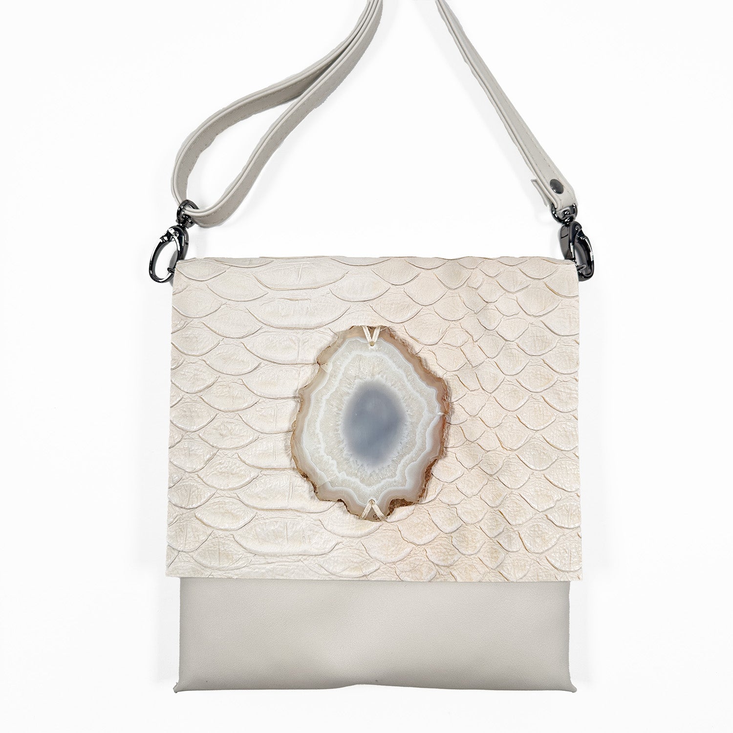 Portrait-style off white Italian leather cross-body bag with a matching leather strap, snake embossed flap, gunmetal hardware, and an oval agate stone accent, shown against a white background.