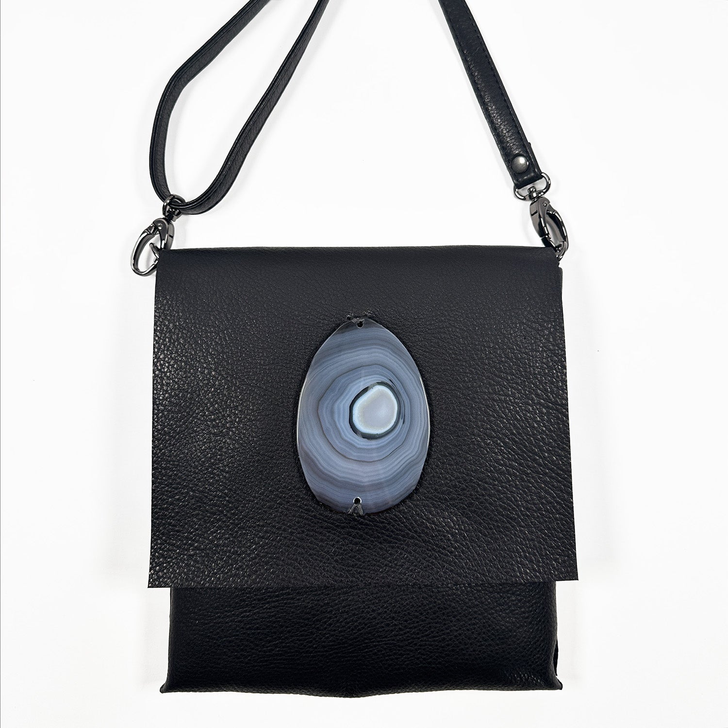 Portrait-style black Italian leather cross-body bag with a matching leather strap, gunmetal hardware, and an oval agate stone accent, shown against a white background.