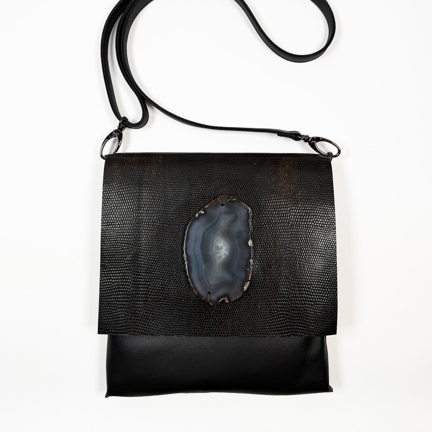 Dark brown leather bag with a central stone design on a white background
