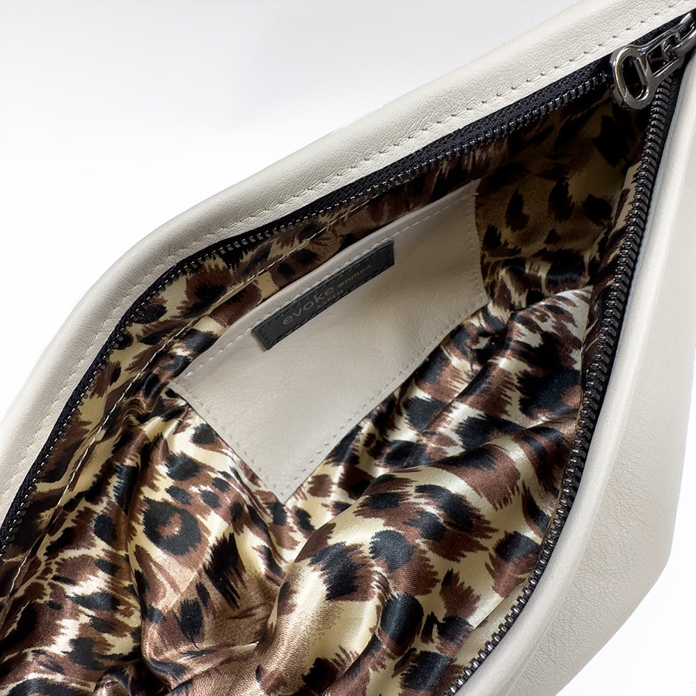 Introducing the sophisticated Sienna - putty by evokewomen: an open design crafted from white leather with a bold leopard print lining and a handy inner pocket. Ideal for fashion enthusiasts, this versatile accessory effortlessly shifts from day to night.
