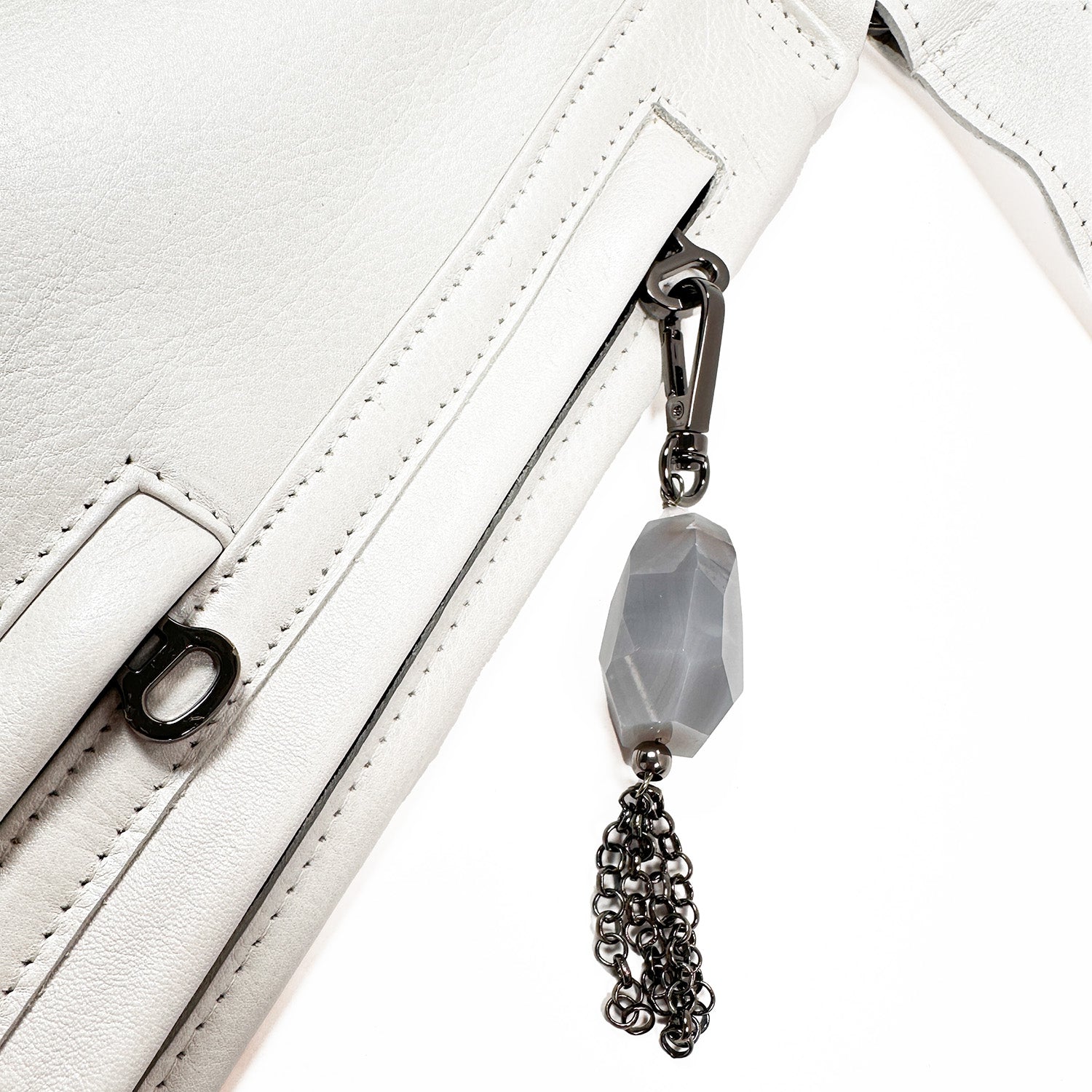 Close-up of the Sienna bag by evokewomen, featuring pearl white leather and a stylish tassel, highlighting its versatility.