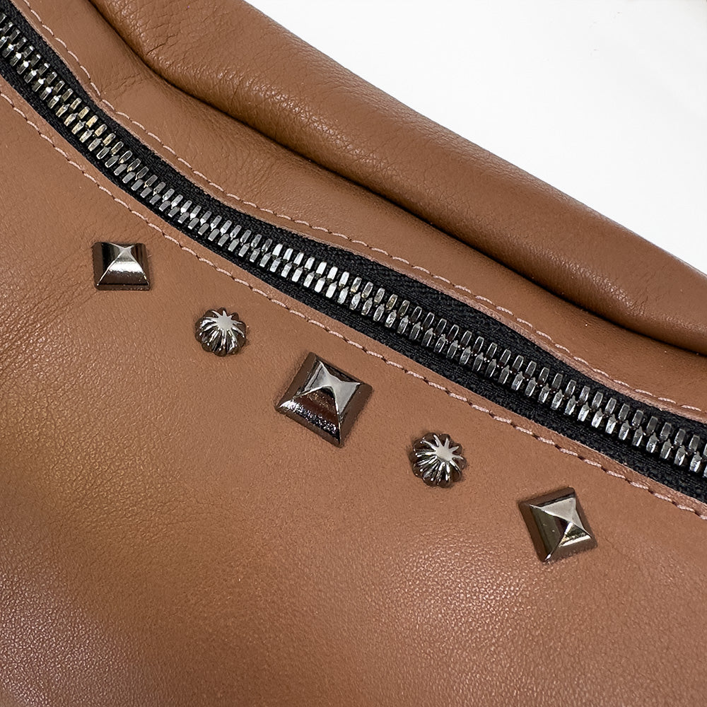 Close-up of the STELLA - western brown sling bag by evokewomen, featuring a silver zipper and decorative metal studs, highlighting the elegance of fashion accessories.