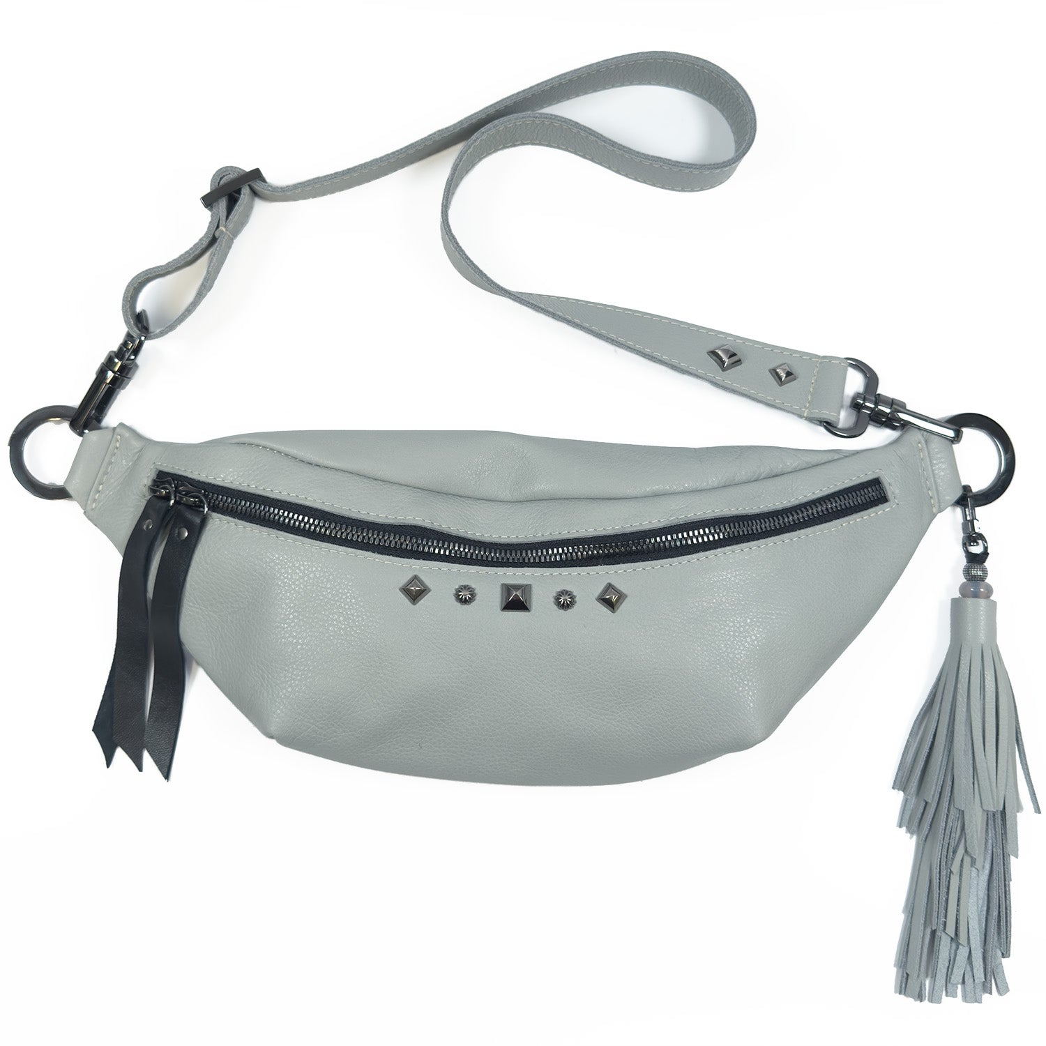 STELLA - light smoke, a gray leather sling bag by evokewomen, showcases a black zipper, rivet decorations, a tassel, and an adjustable strap.
