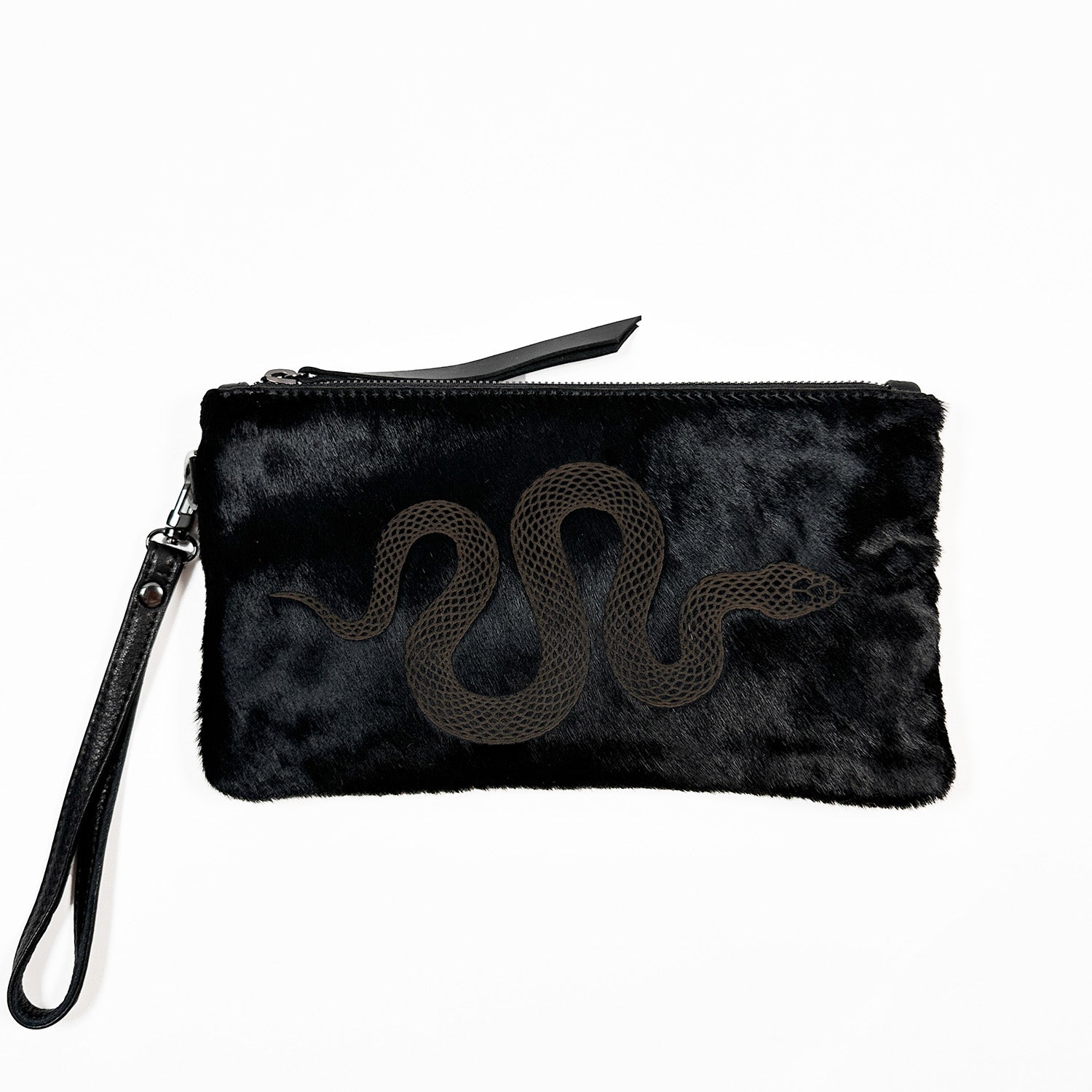 Introducing the VICTORIA - black - laser snake by evokewomen: a wristlet clutch with a striking laser-engraved snake design on fur, featuring a zip closure and strap. This versatile style is perfect for any occasion.