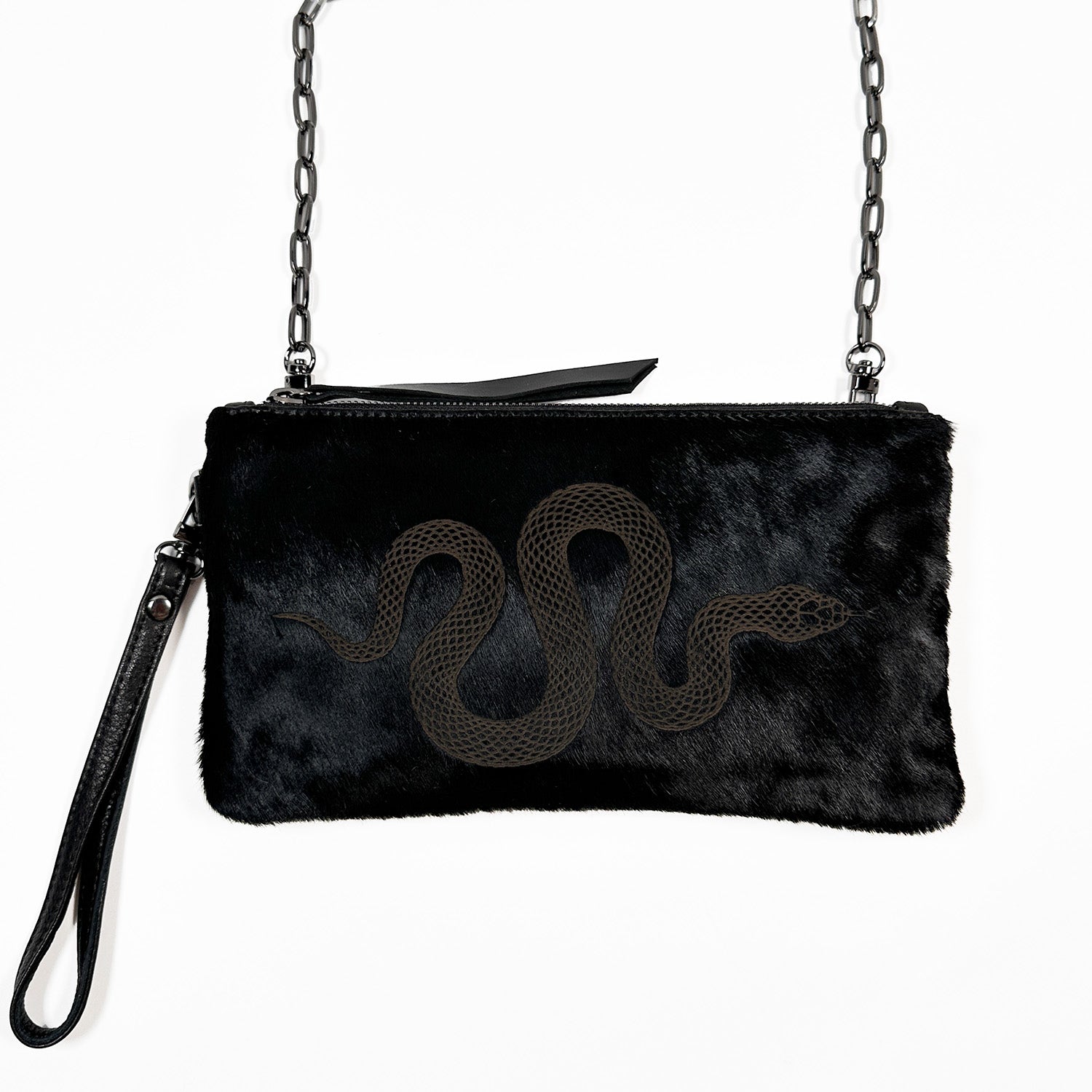 Introducing the VICTORIA - black - laser snake by evokewomen: a versatile black fur purse adorned with a chain strap and wristlet. It showcases an exquisite laser-engraved snake design on the front, making it perfect for any occasion.