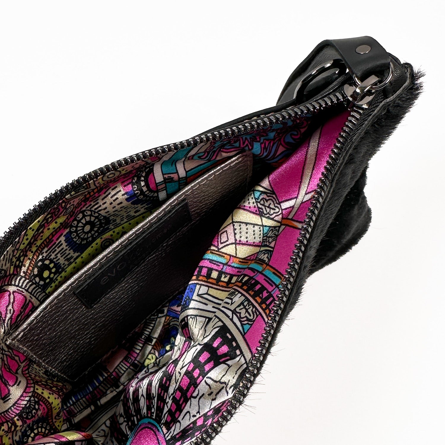 Unzip the VICTORIA - black - laser eye pouch from evokewomen to reveal its vibrant patterned lining and practical interior pocket. This adaptable accessory effortlessly converts into a stylish clutch, perfect for an elegant evening out.