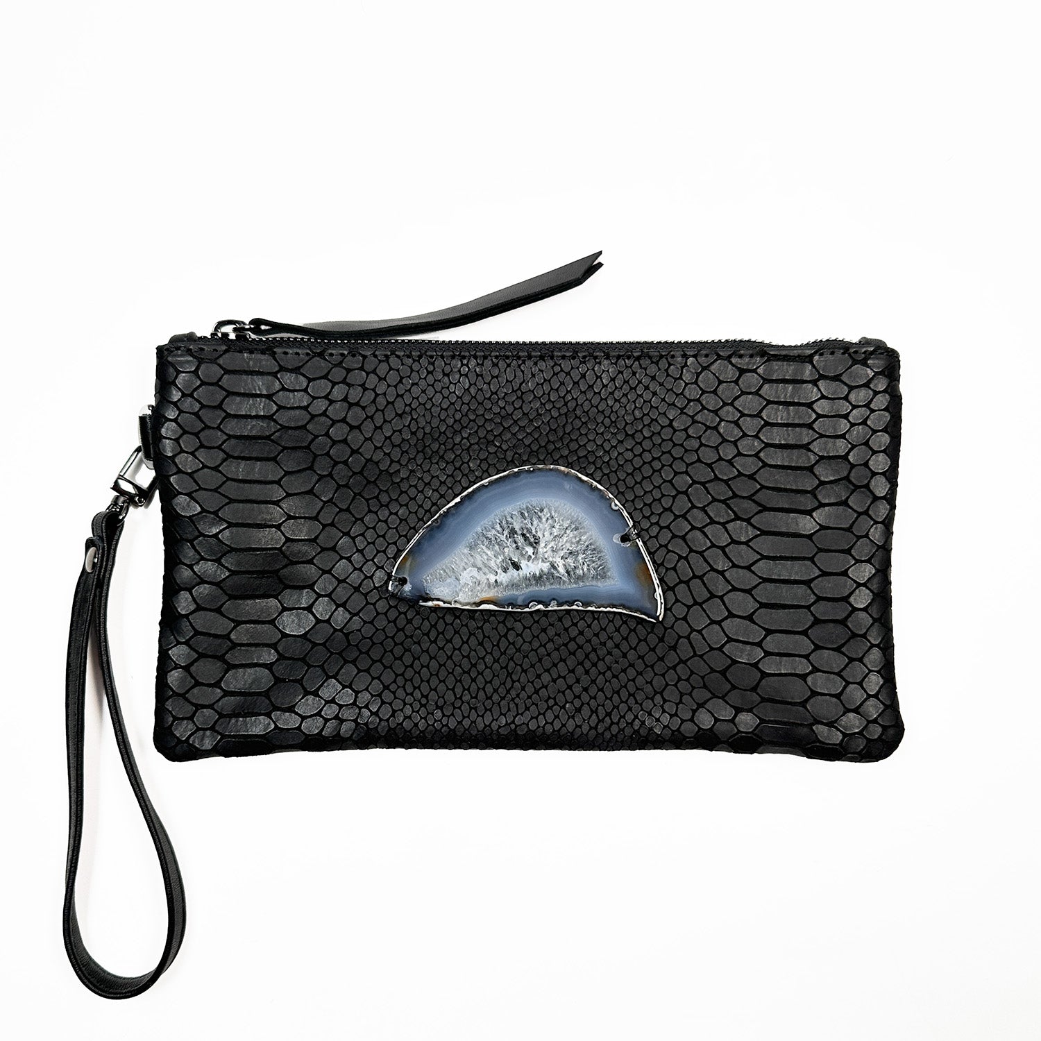 The Victoria Bag in black snake-embossed leather by Evoke Women, featuring a striking agate decoration. This versatile accessory can be worn as a crossbody, belt bag, or wristlet, showcasing a sleek design that transitions effortlessly from day to night.