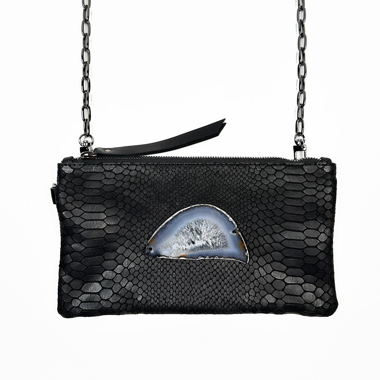 The Victoria Bag in black snake-embossed leather by Evoke Women, featuring a striking agate decoration. This versatile accessory can be worn as a crossbody, belt bag, or wristlet, showcasing a sleek design that transitions effortlessly from day to night.