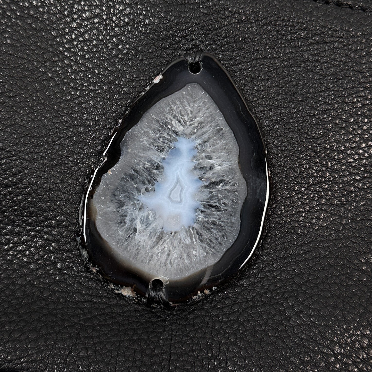 The Victoria Bag in black Italian leather by Evoke Women, featuring a striking agate decoration. This versatile accessory can be worn as a crossbody, belt bag, or wristlet, showcasing a sleek design that transitions effortlessly from day to night.