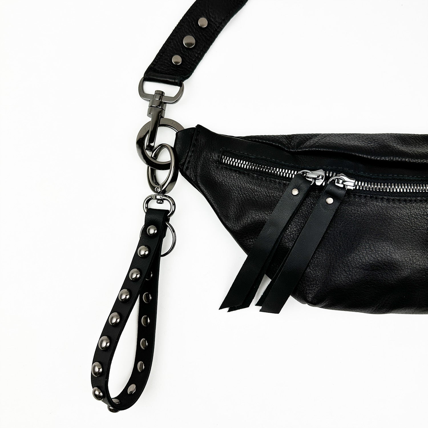 KEY RING - BLACK STUDDED by evokewomen, featuring a black leather design with metal zippers, an edgy functional strap, and gunmetal accessories, displayed against a white background.