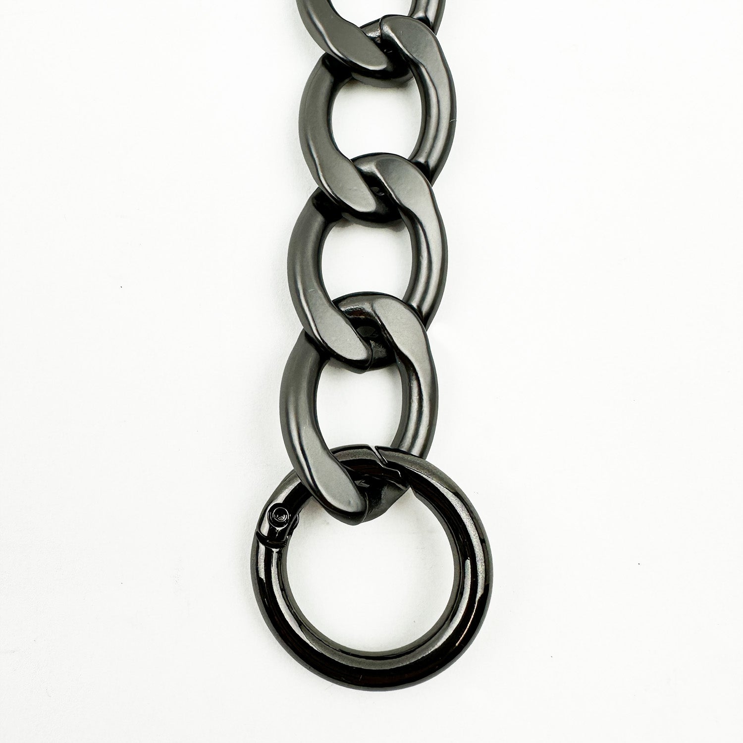 Close-up of the LARGE LINK CHAIN - SHOULDER LENGTH from evokewomen, featuring a circular clasp and a sleek gunmetal finish, displayed against a white background.