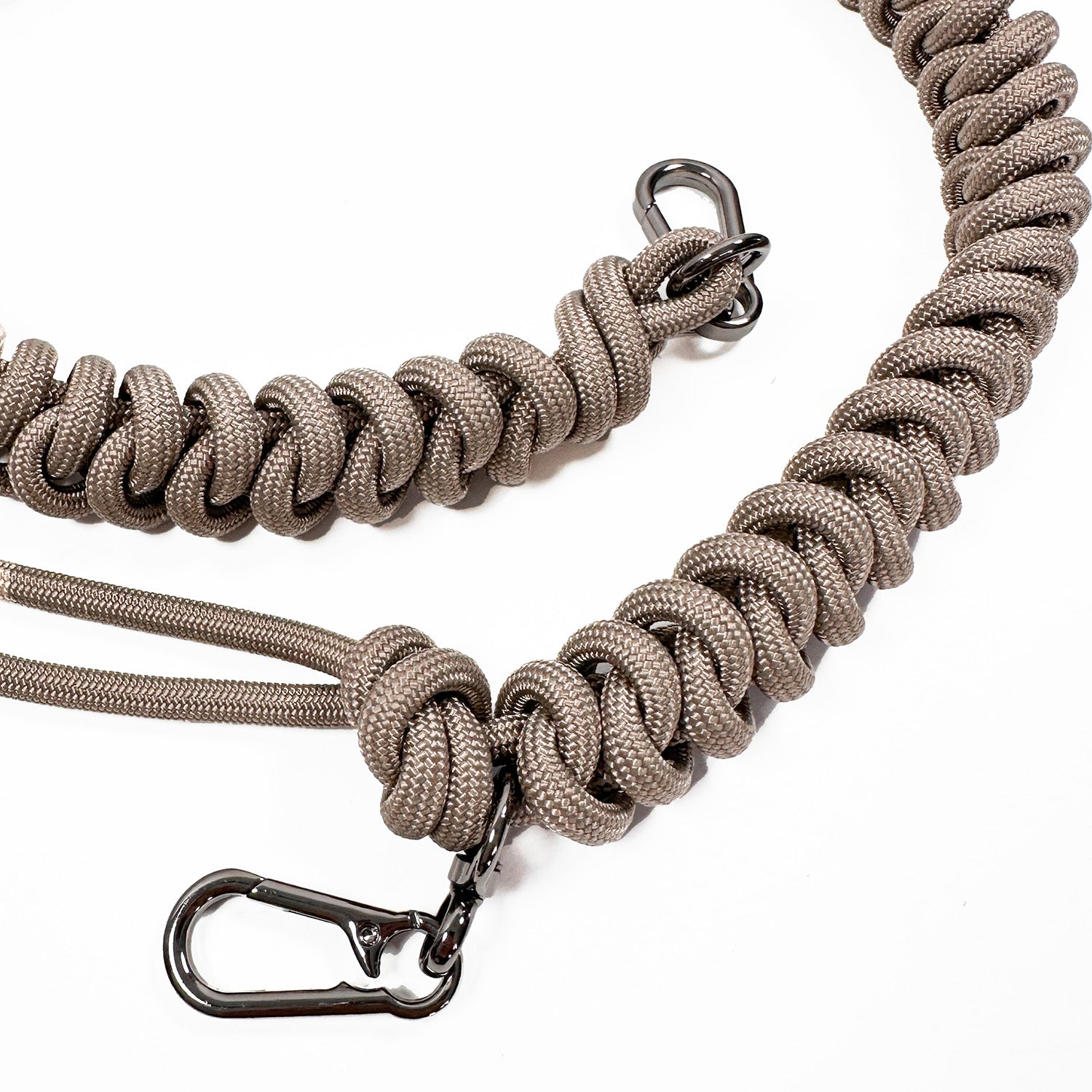 Detail of sand colored knotted paracord strap with 2 high end gunmetal colored swivel hooks on white background.
