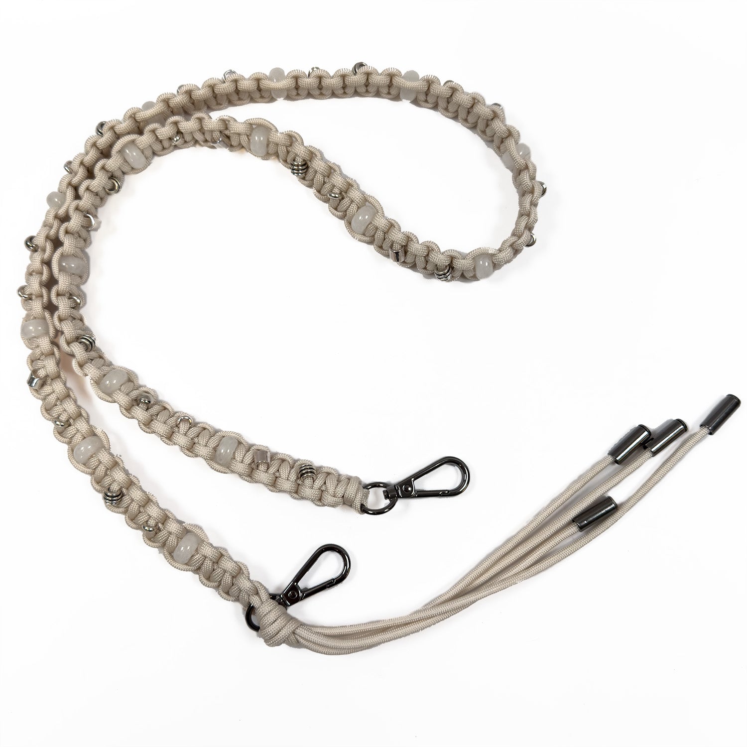 The Almond Knot Shoulder Strap by evokewomen features a beige braided design with gunmetal accessories and two metal clips, complemented by elegant tassels on a white background.