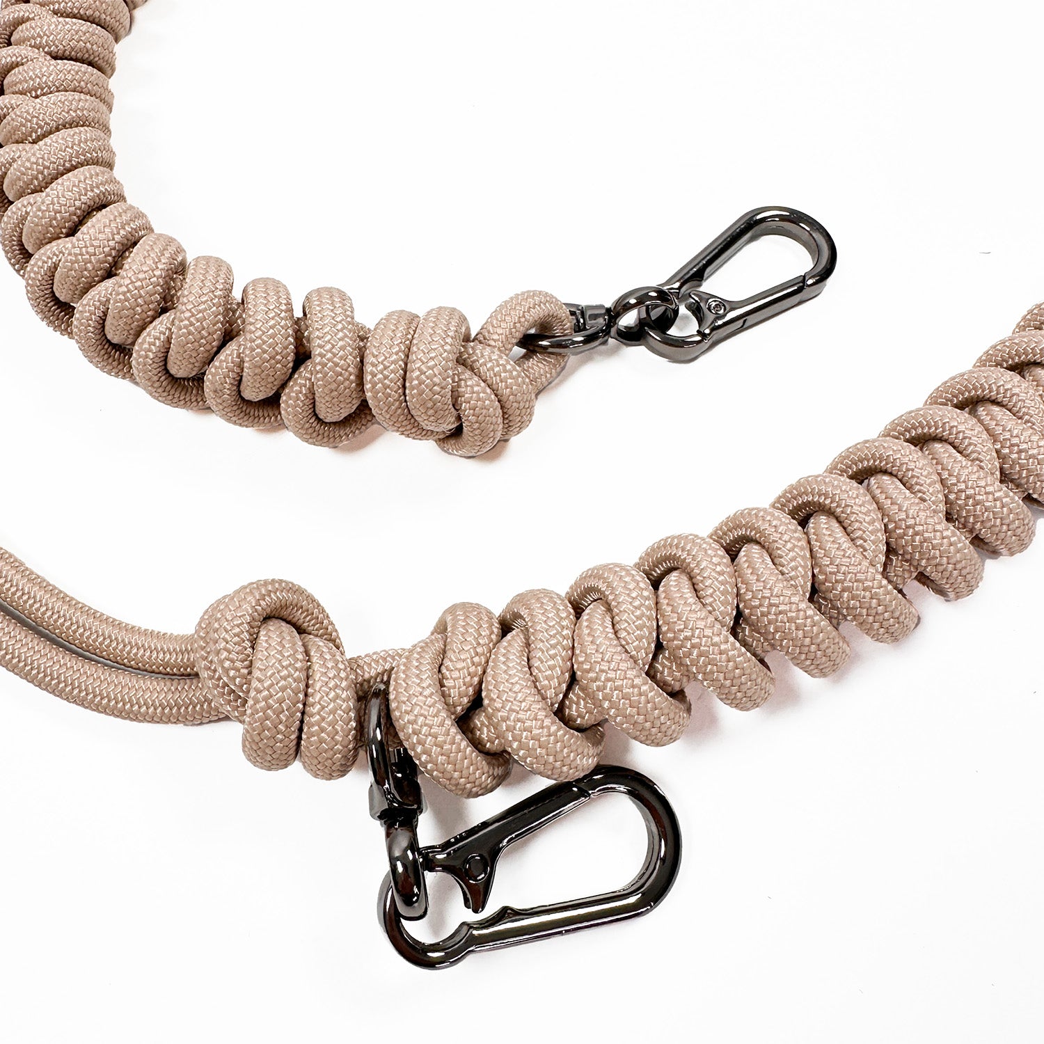 Detail of light beige knotted paracord strap with 2 high end gunmetal colored swivel hooks on white background.