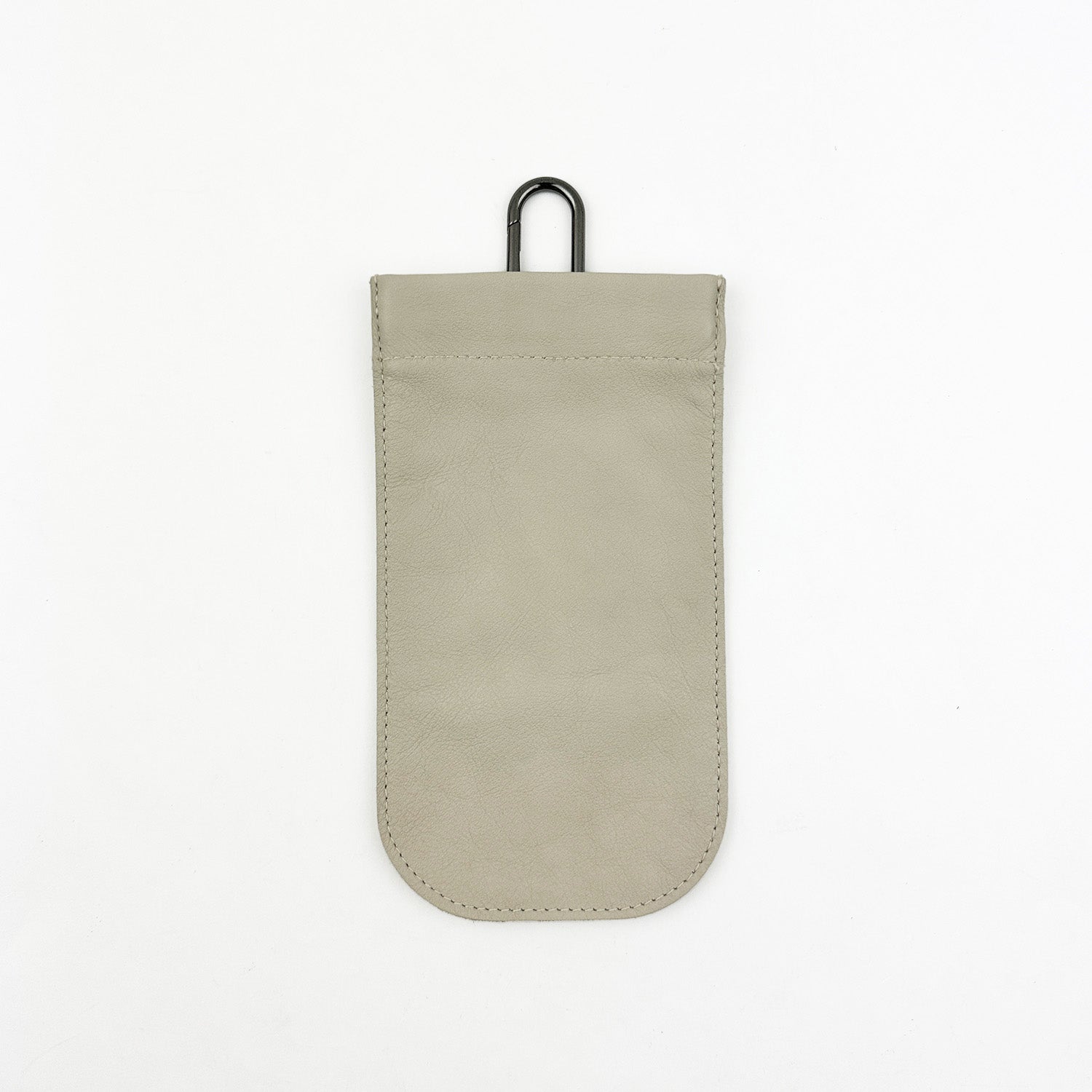 The putty-colored leather SUN-GLASS POUCH from evokewomen features a rounded bottom and is equipped with a premium gunmetal spring hook at the top, complemented by a sleek squeeze frame closure, all set against a white background.