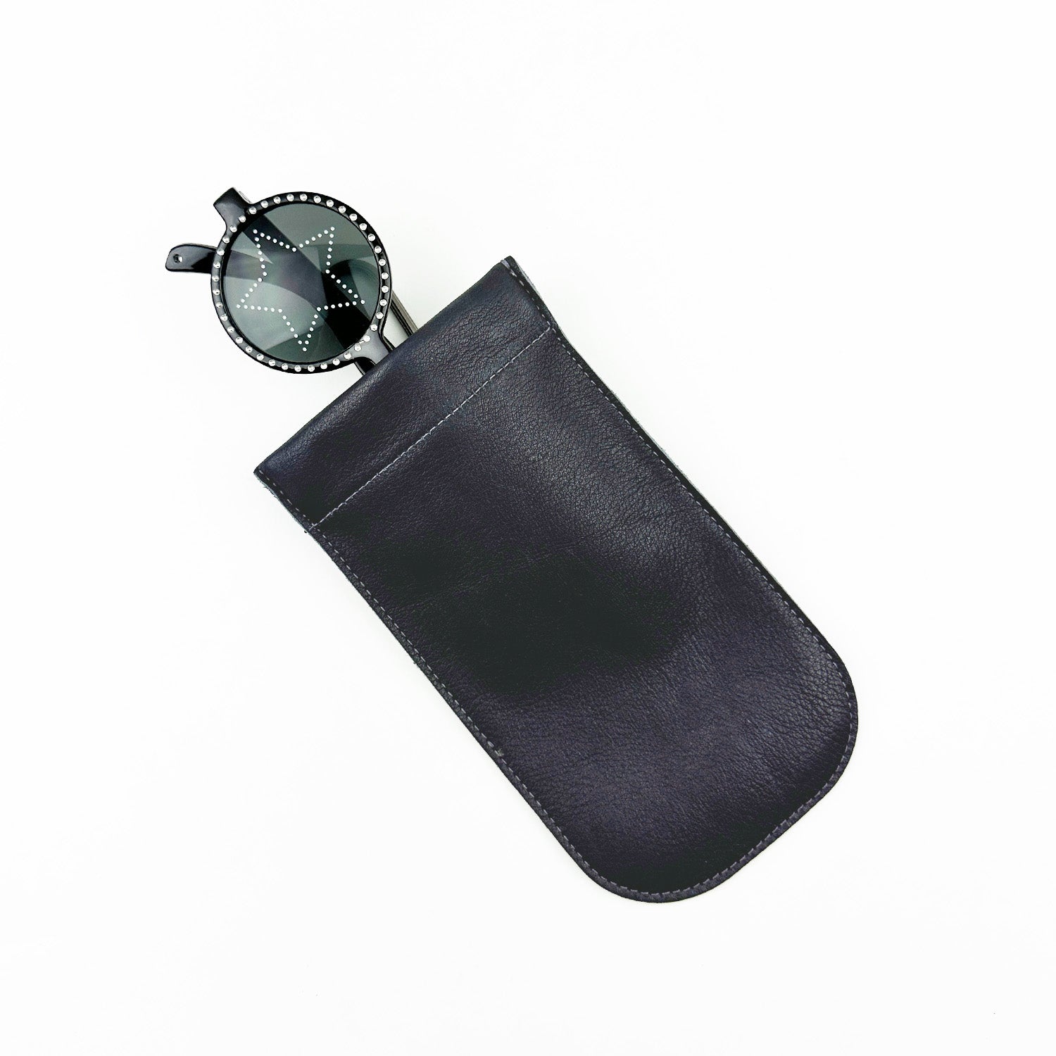 These black sunglasses from evokewomen offer stylish eyewear protection with their round lenses and studded rims, elegantly complemented by their partial nestling in a sleek navy SUN-GLASS POUCH against a pristine white background.