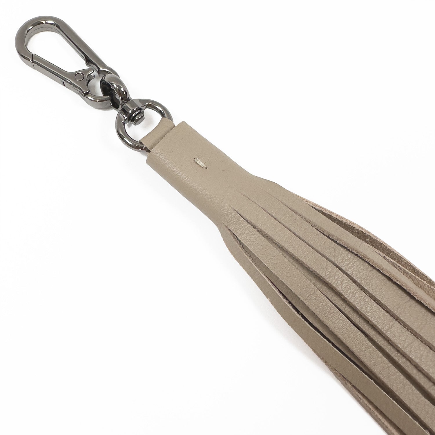 The TASSEL XXL - sand by evokewomen is a tan leather tassel keychain with a metal clasp, featuring an XXL tassel for a bold and unique accessory.