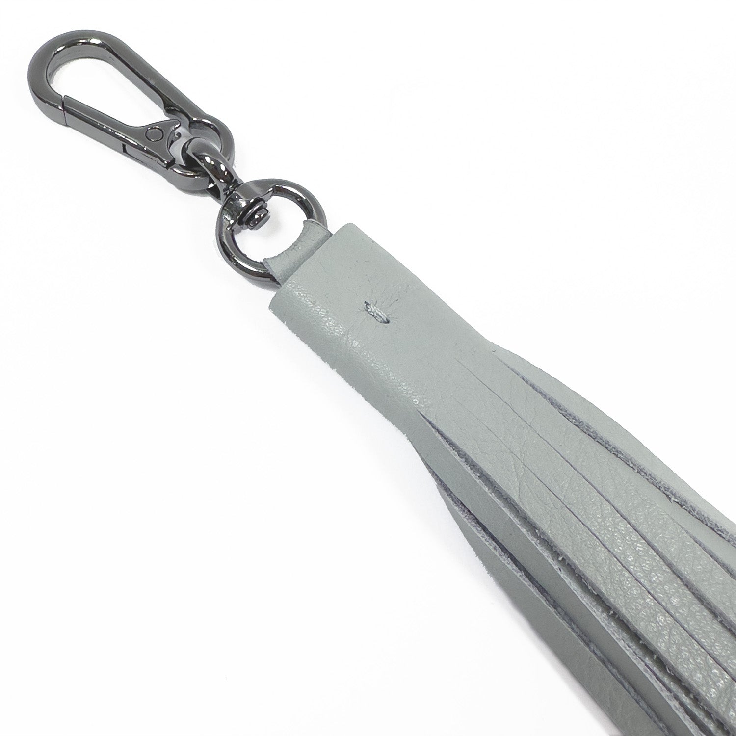 A close-up of the TASSEL XXL in light smoke by evokewomen, showcasing a gray leather keychain with a striking gunmetal clasp.