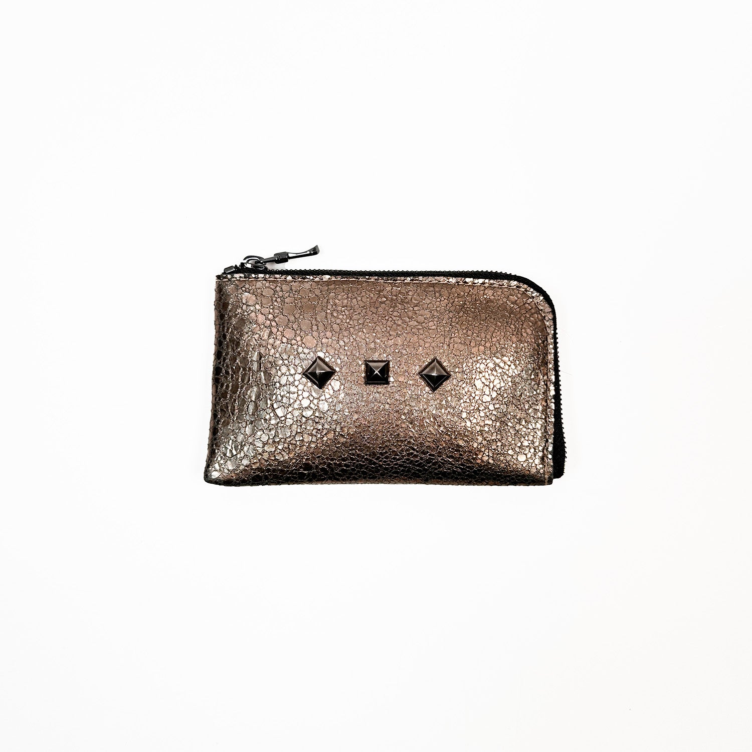 The MINI WALLET - antique gold by evokewomen is a compact and stylish leather pouch with a distinctive design, featuring a black zipper and three decorative studs on one side, making it an elegant mini wallet.