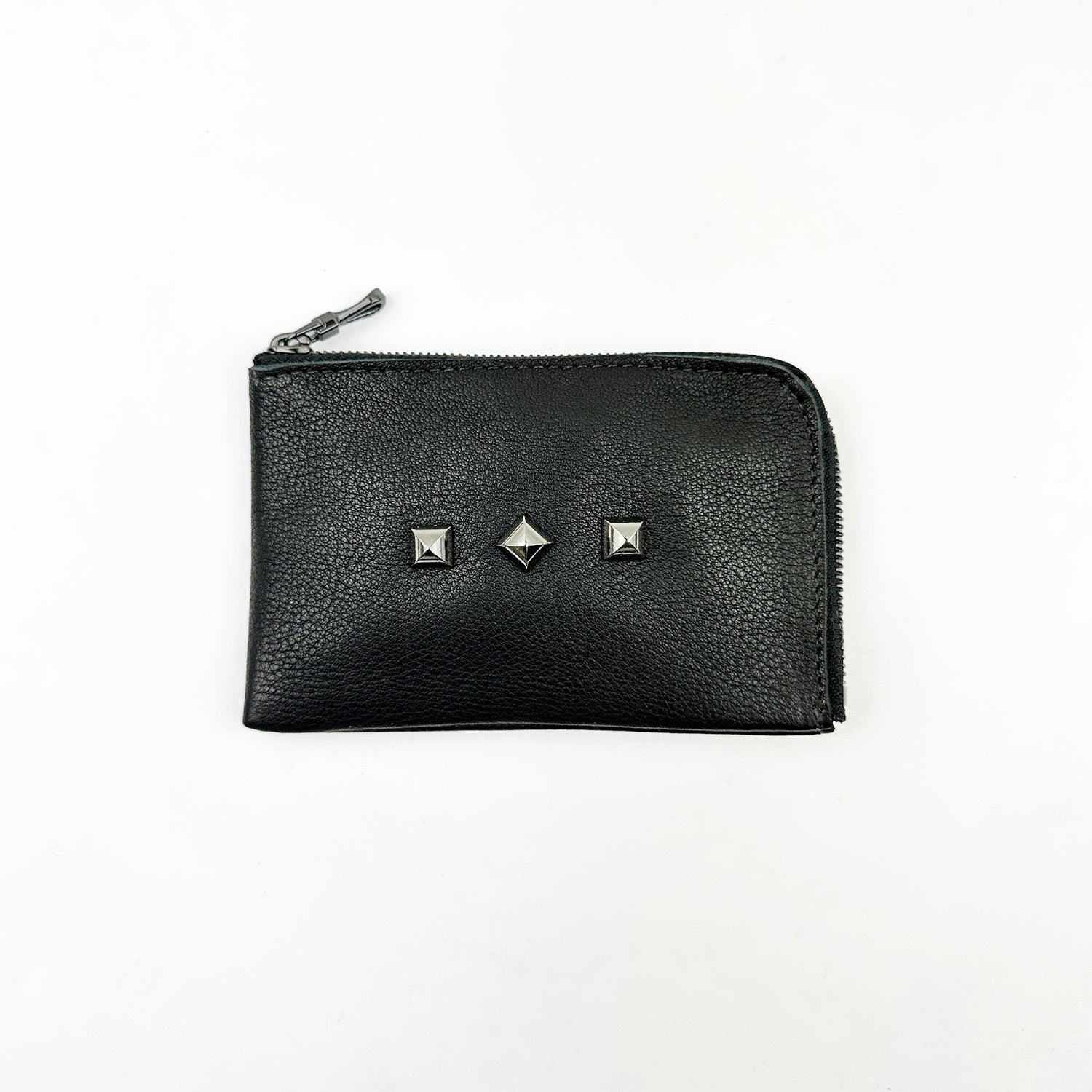 Evokewomen's MINI WALLET - BLACK features a zippered pouch and three metal studs, accentuating its unique design against a white background.