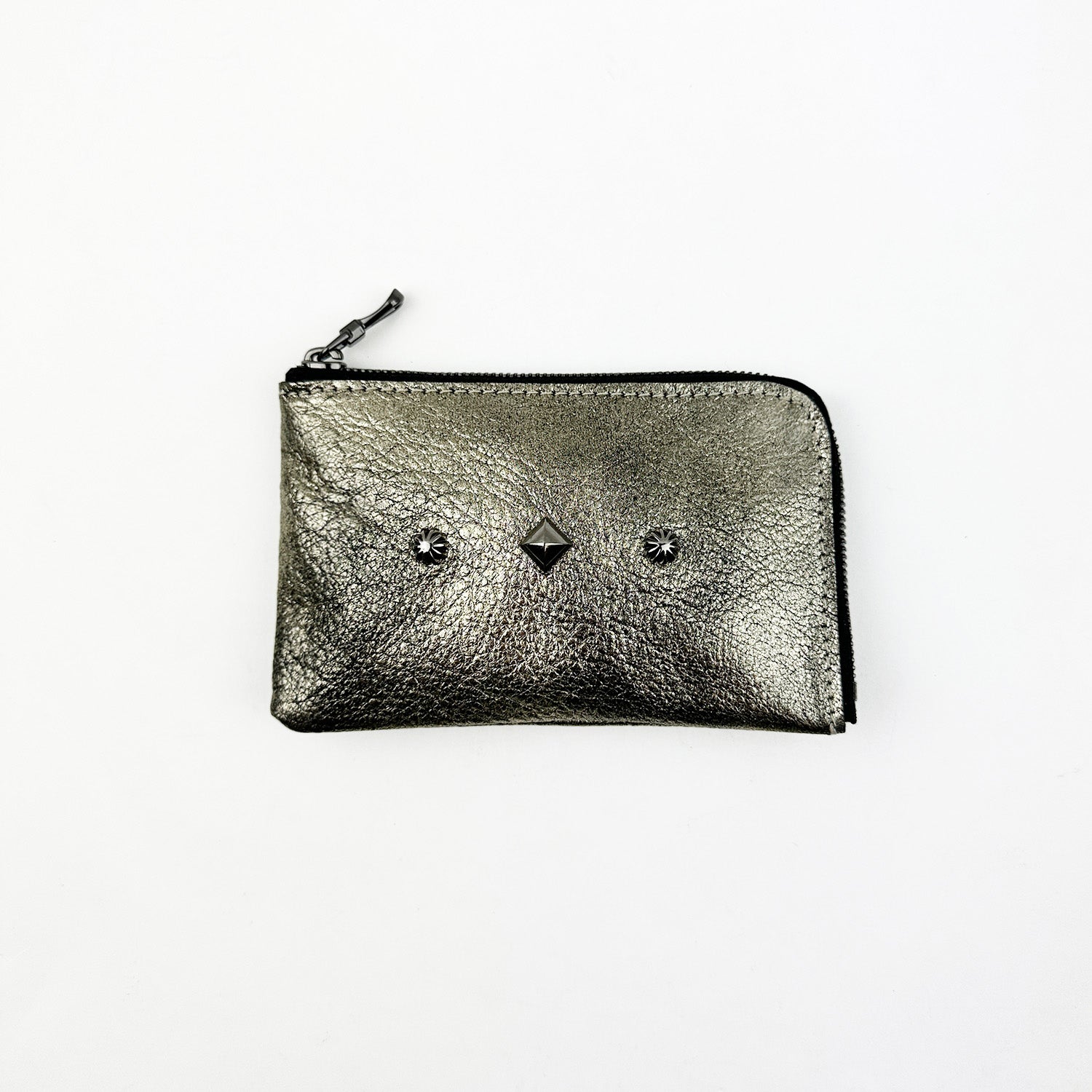 Evokewomen's MINI WALLET - METALLIC is a stylish silver zippered pouch adorned with three stud details, designed to resemble a trendy mini wallet against a plain white background.