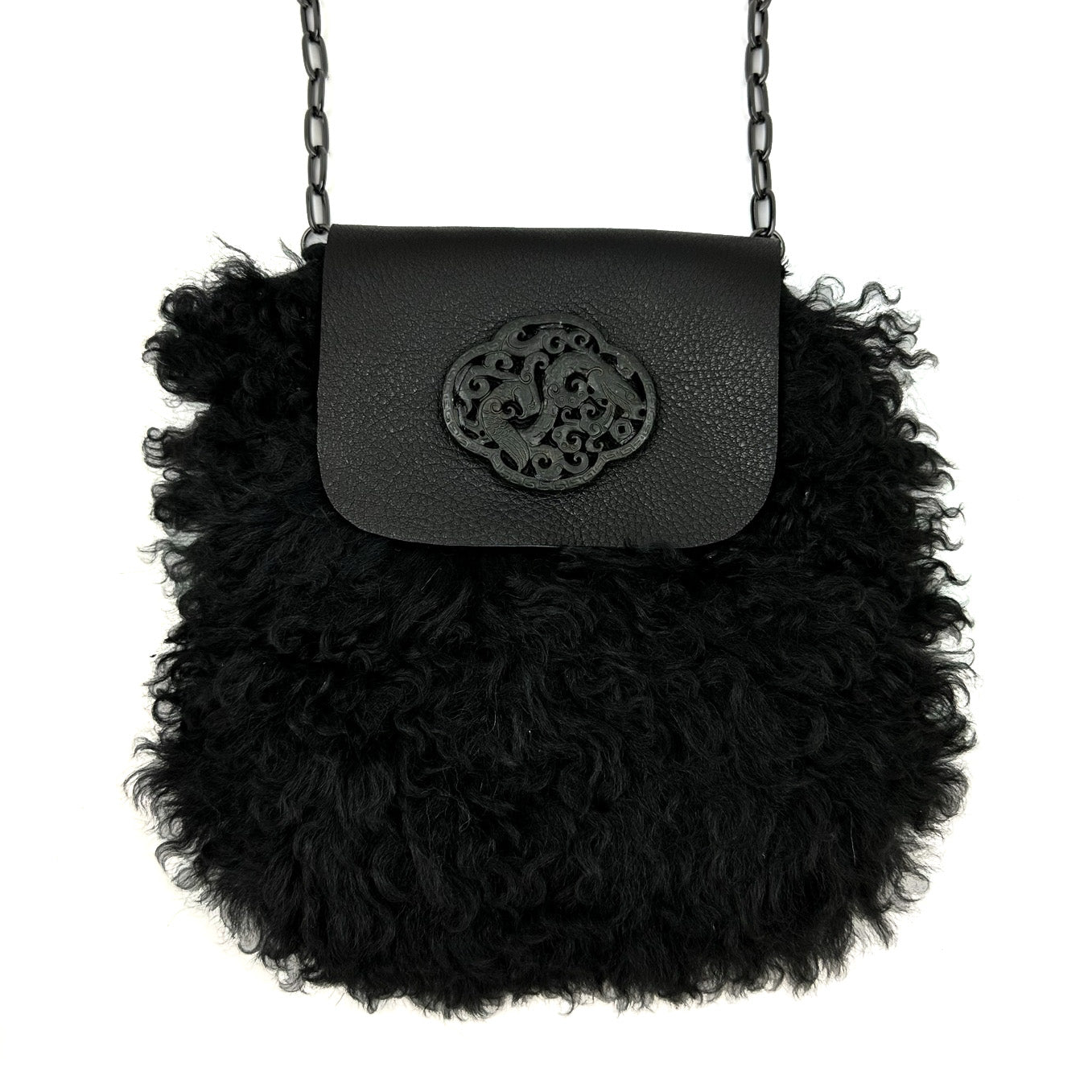 Introducing the MIA - BLACK by evokewomen, a stylish handbag featuring a unique curly fur texture. This versatile piece is accented with a leather flap and a decorative circular emblem, transitioning effortlessly from Cross Body to Shoulder Bag with its elegant chain strap.