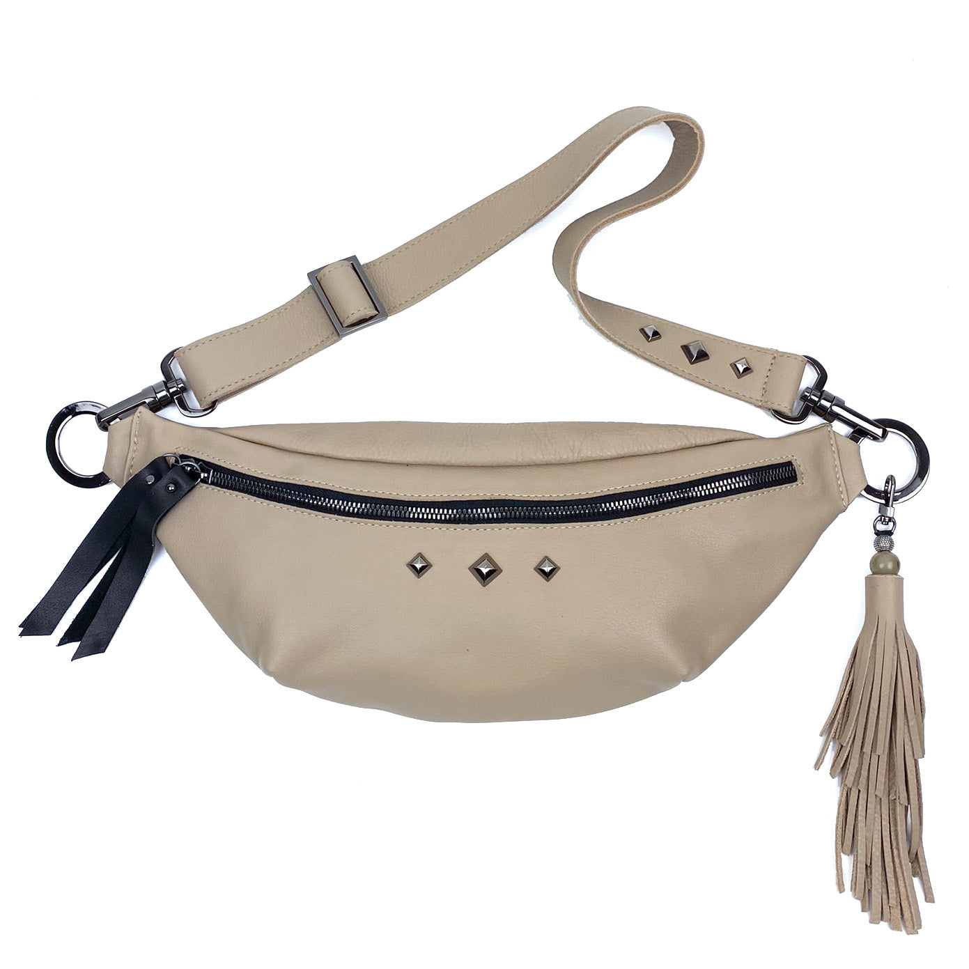 Introducing the STELLA - SAND by evokewomen: a beige leather waist bag featuring an adjustable strap, zipper closure, and chic tassel detail. Adorned with small square studs for a trendy look.
