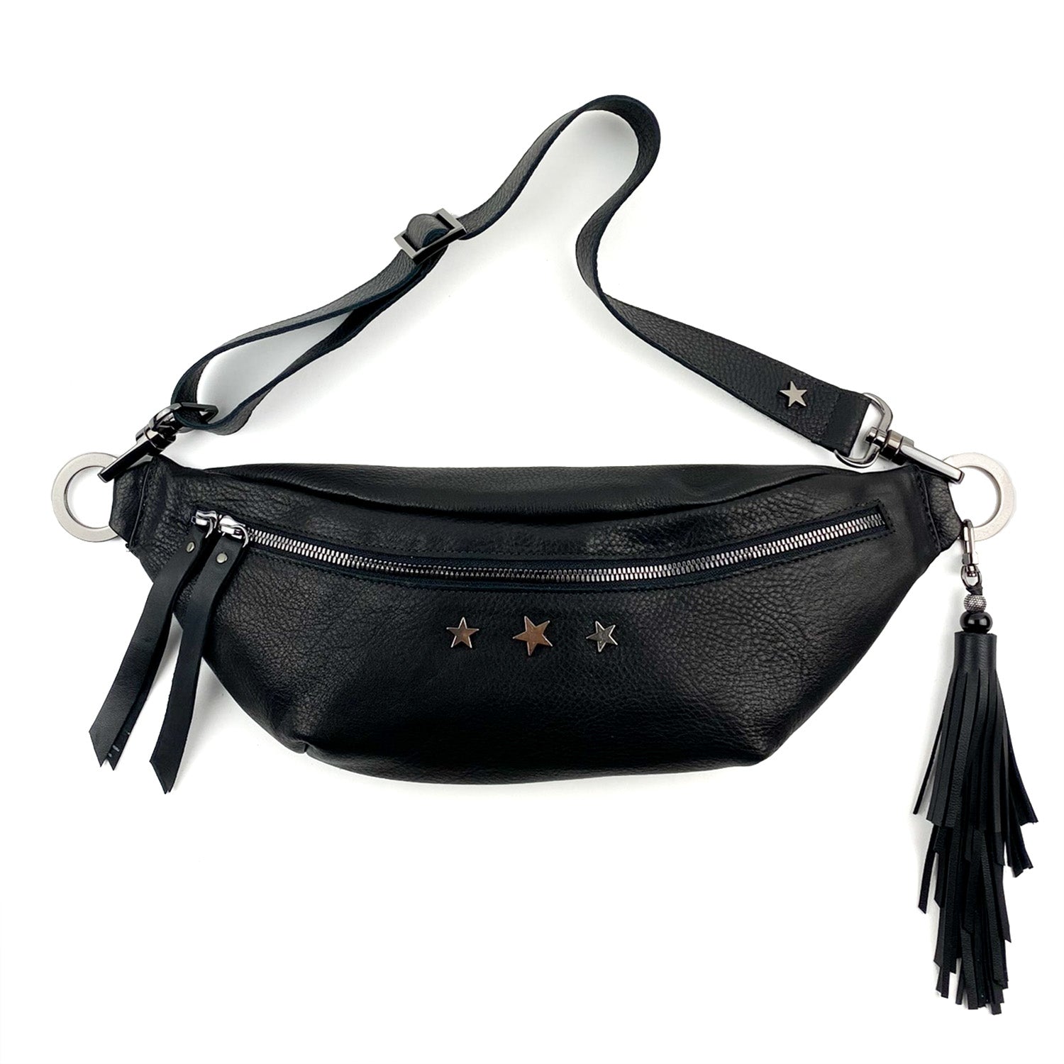 The STELLA - BLACK by evokewomen is a black leather sling bag featuring a zippered front pocket, adorned with three metallic stars and a tassel accessory.