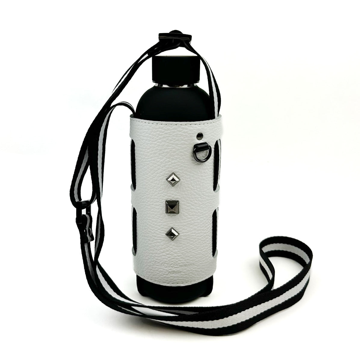 The evokewomen Bottle Carrier in white boasts a sleek black water bottle accompanied by a chic white leather sleeve embellished with silver studs. It also includes a bold black-and-white striped shoulder strap that is adjustable for easy and convenient carrying.